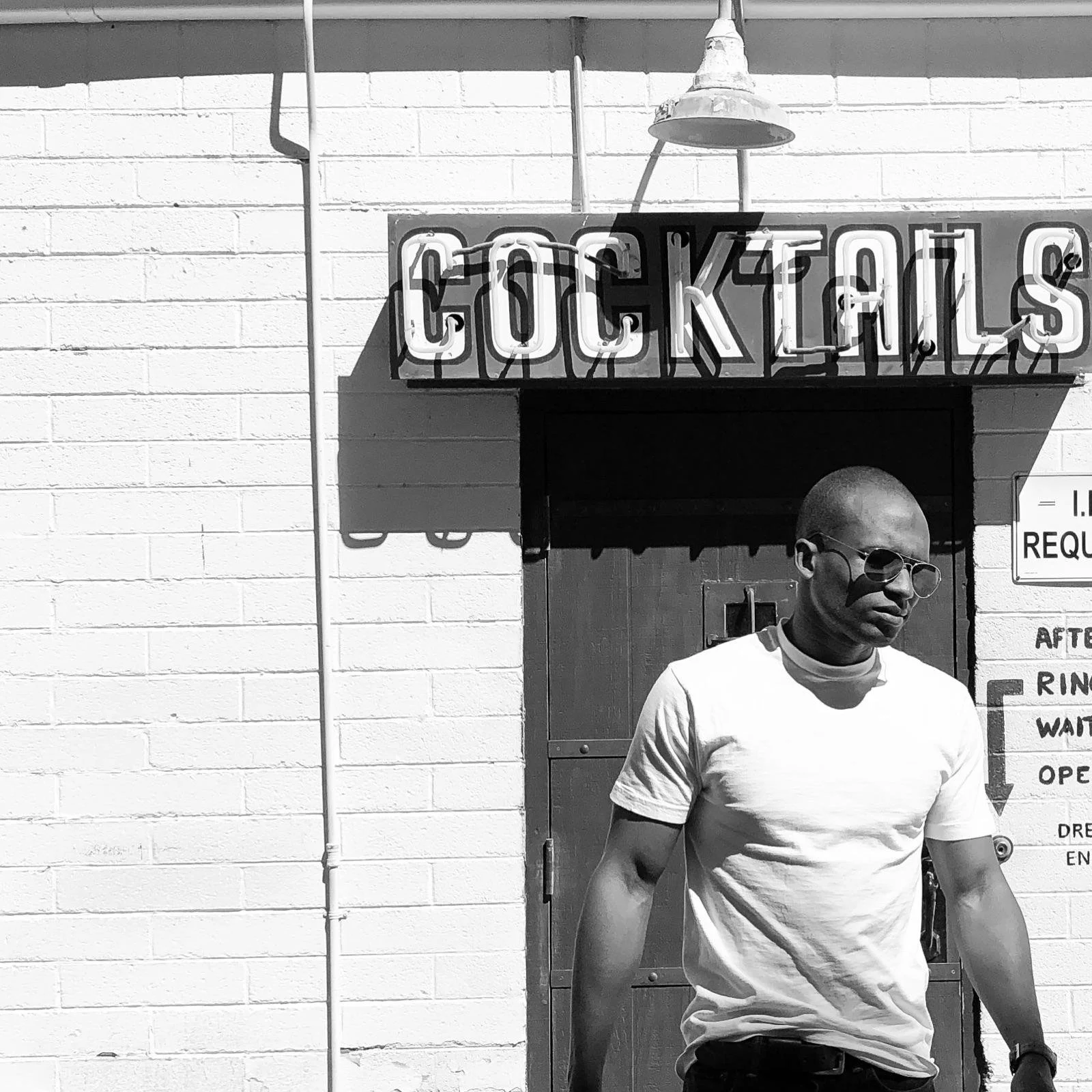 A black-and-white portrait of Erwin Burns outside a cocktail bar in Las Vegas, Nevada.