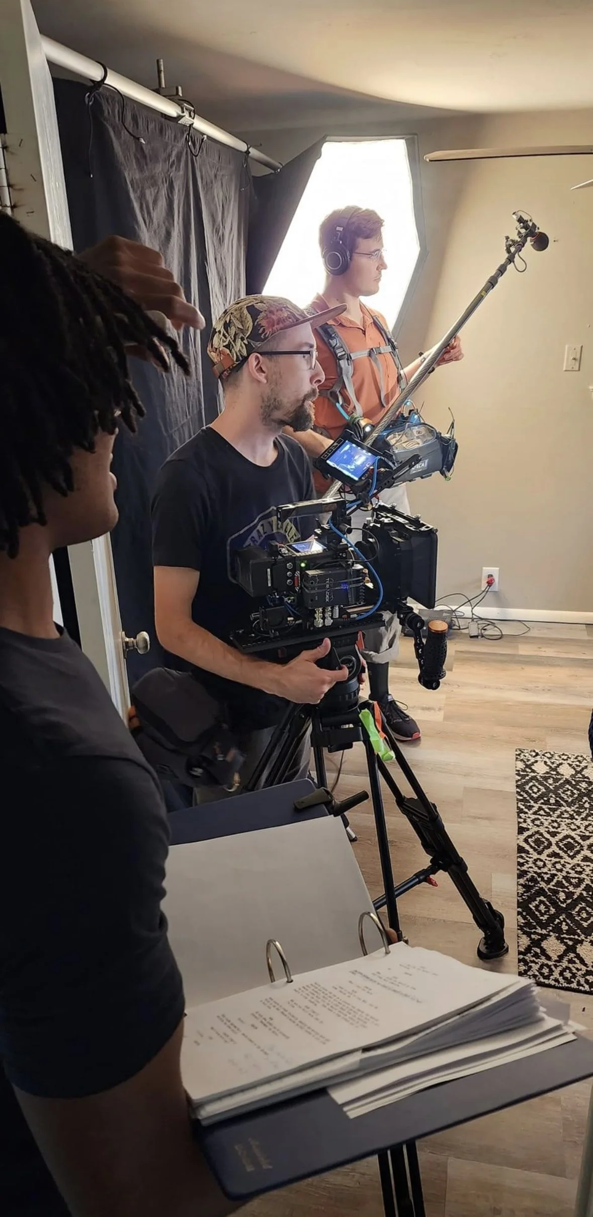 Filmmaking crew on set with camera operator, director, and technical equipment during production.