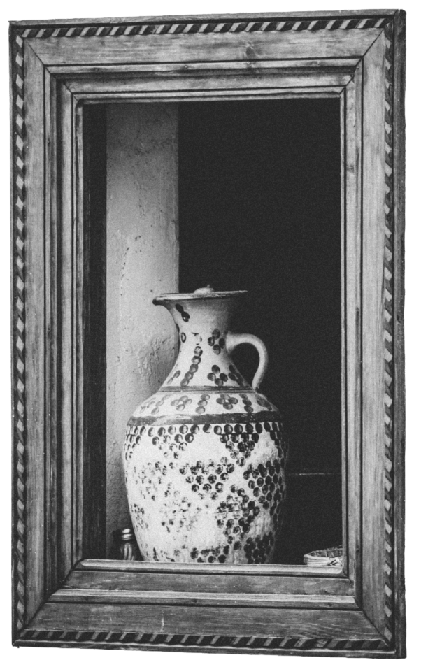 A ceramic vase with a handle inside a wooden display case.