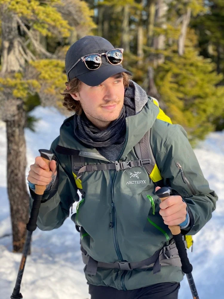 Photographer Ryan Tidman standing outdoors in a snowy forest wearing winter gear.