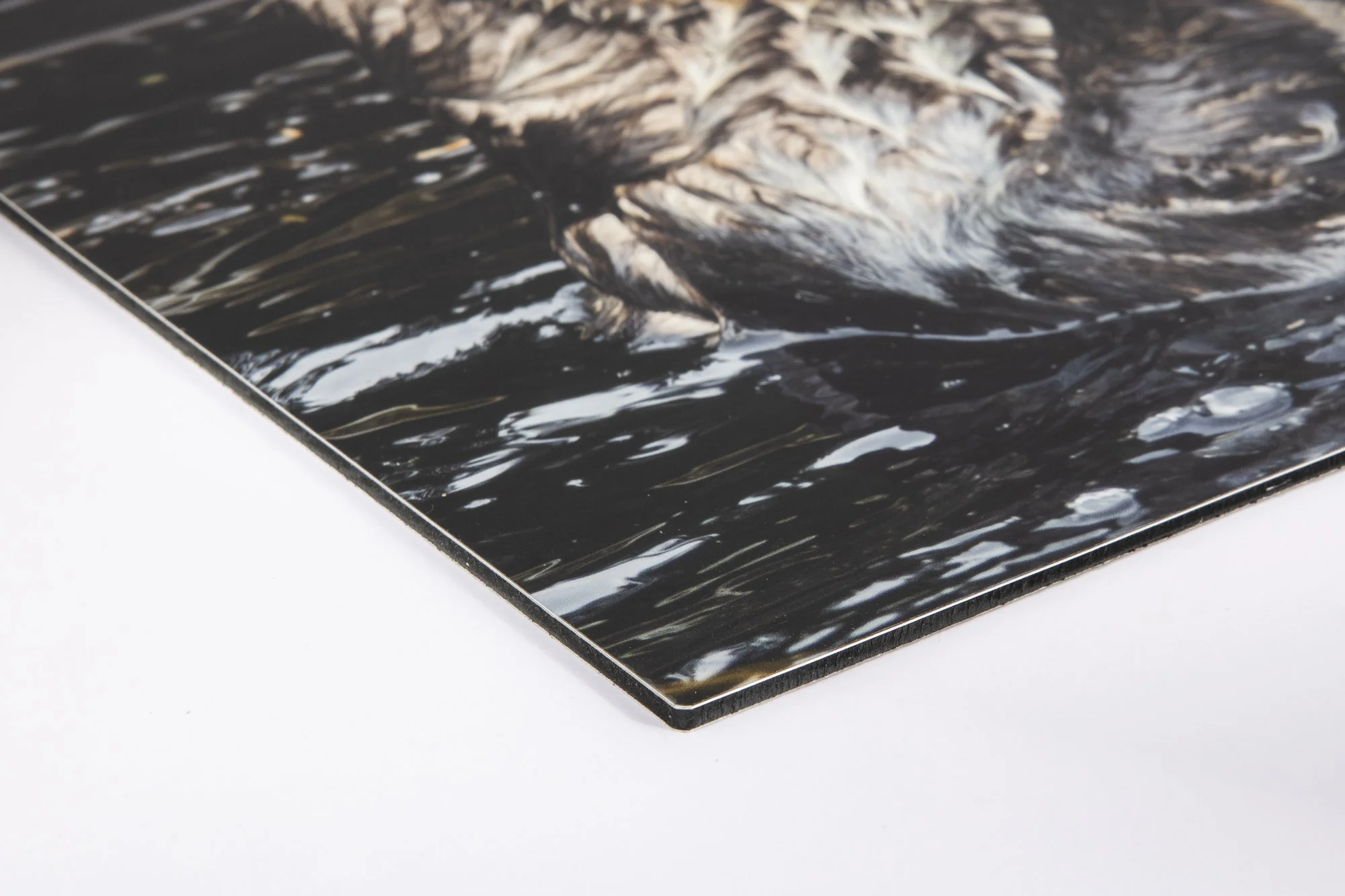 Close-up of a photograph or artwork with swirling dark and light colors, partially visible in the corner of a flat surface.