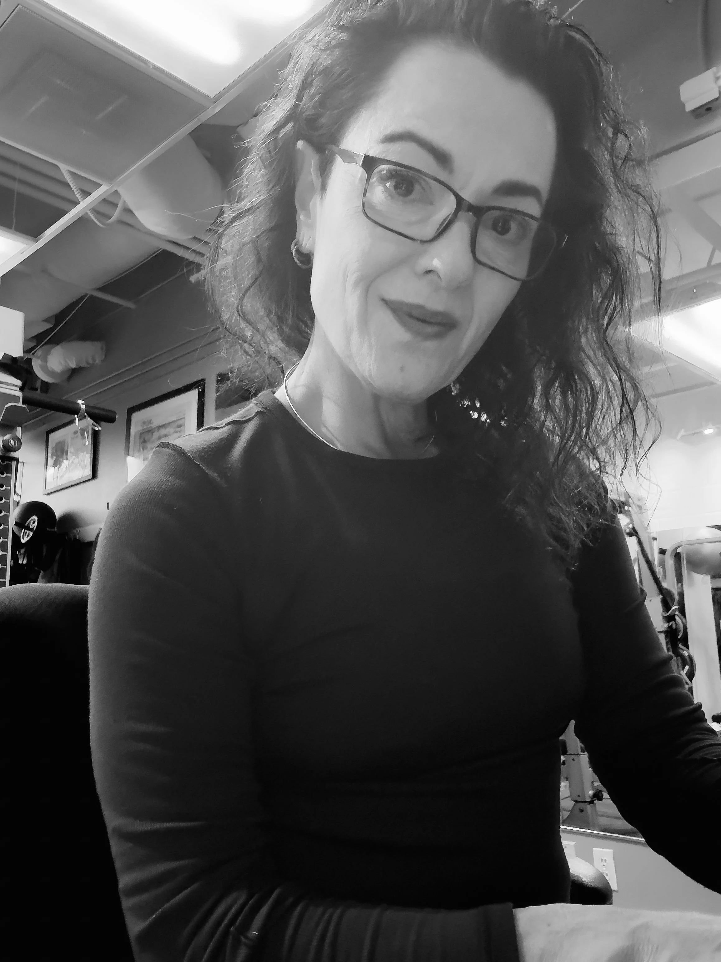 Portrait of Selina Sahba, IT and brand manager, wearing glasses and photographed indoors in black and white.