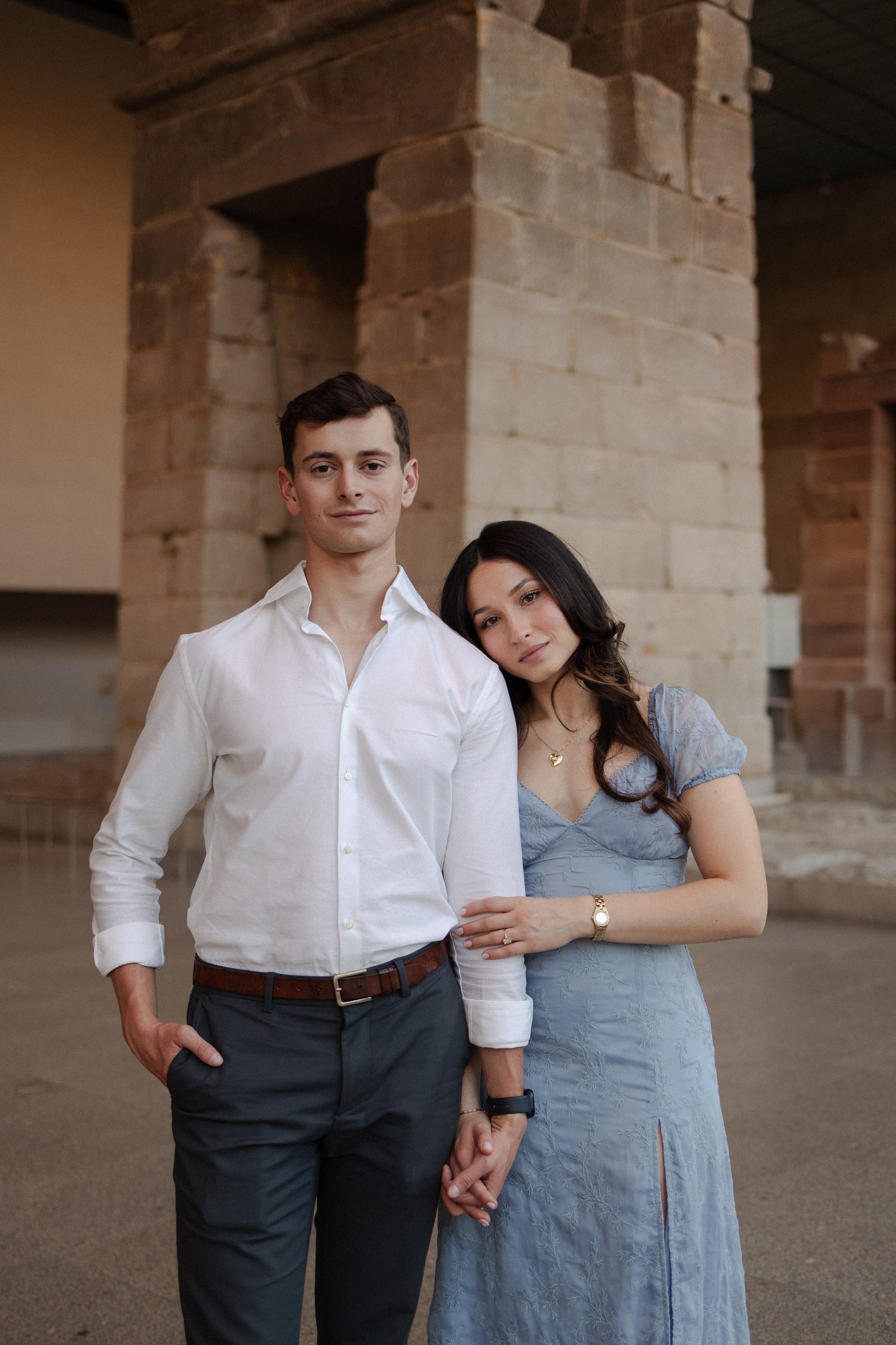 Dominique Paulette Photography, Somerville bride and groom standing close together indoors with brick structures in the background, holding hands and posing for the camera.