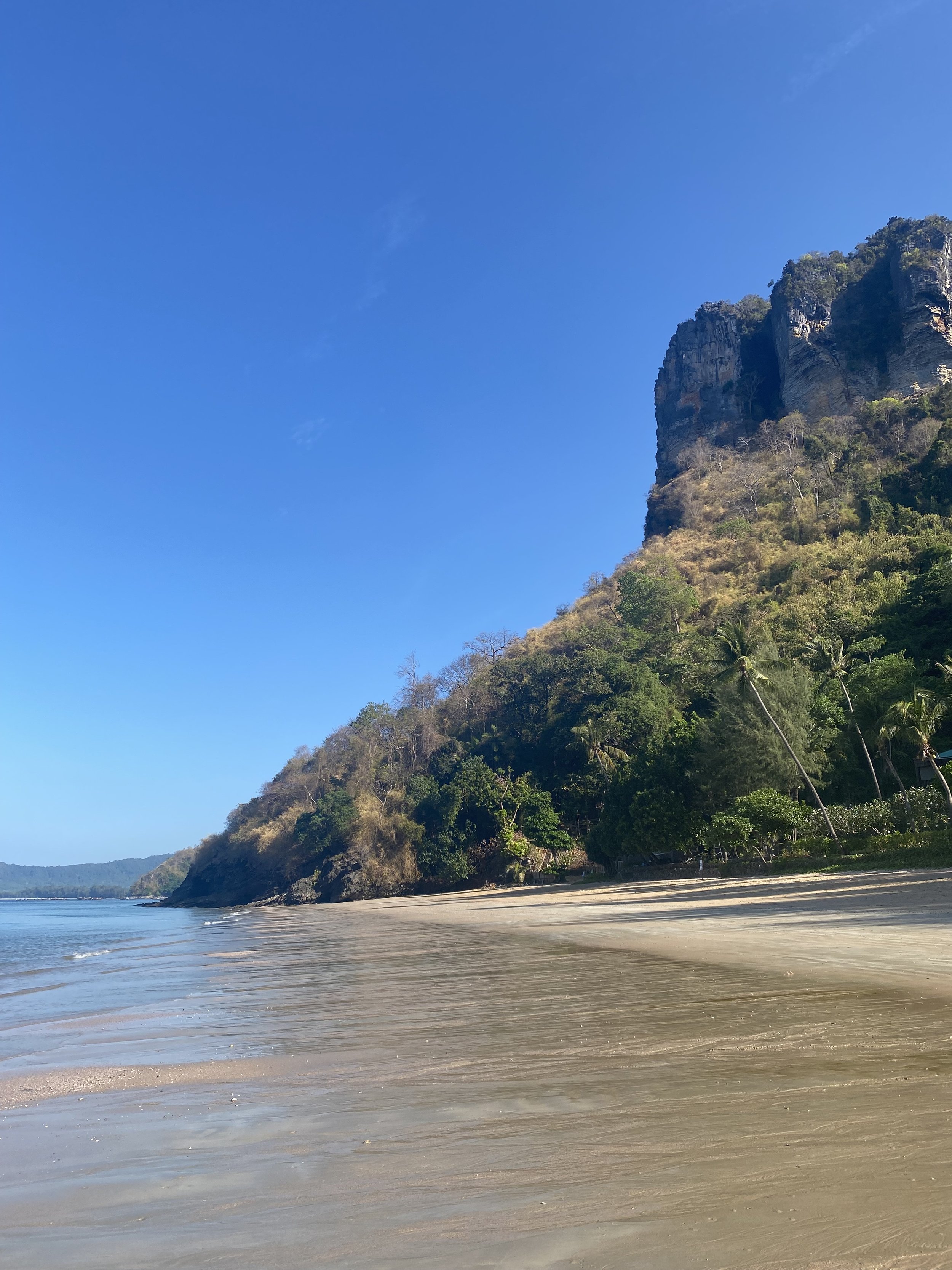 Pai Plong Beach in Krabi, Thailand, with turquoise water and lush limestone cliffs
