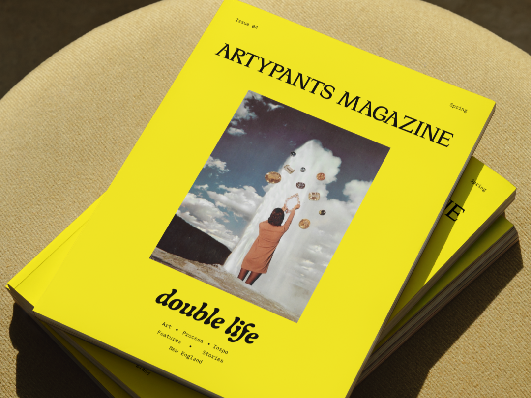 Stack of bright yellow magazines titled 'ARYPANTS MAGAZINE' with a cover photo of a woman in a brown coat reaching up towards floating objects against a sky with clouds.
