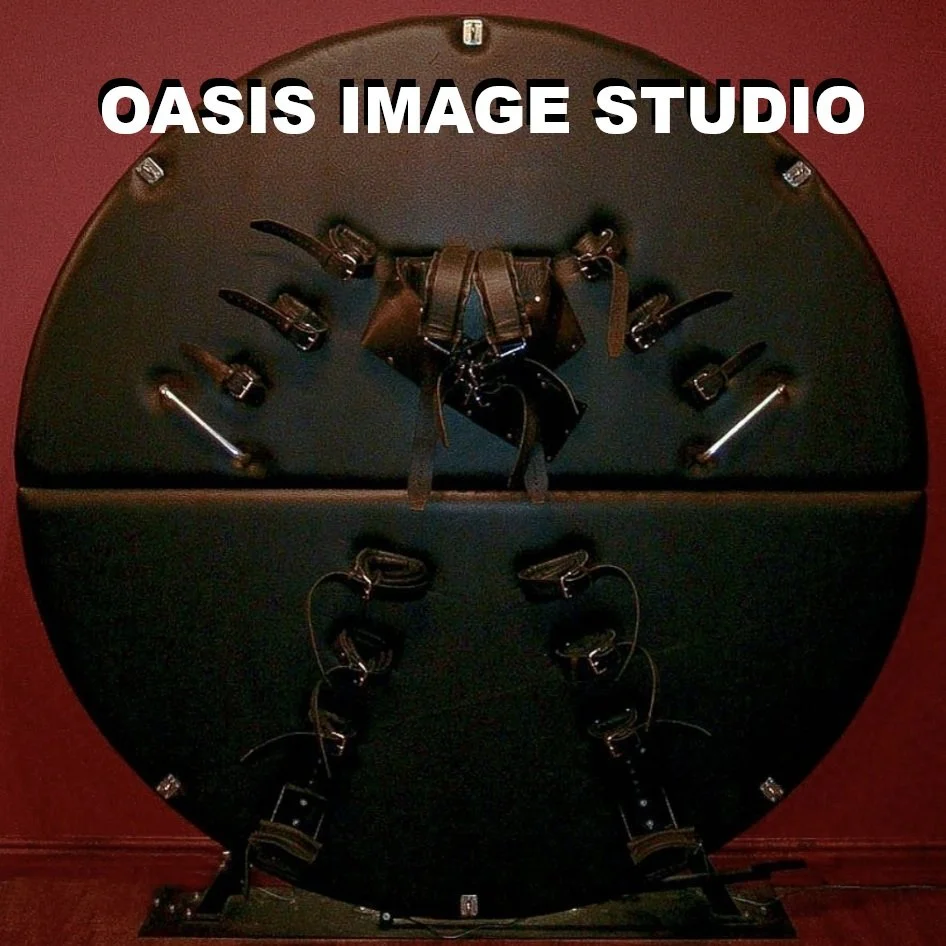 A round black display table with multiple leather straps and metal buckles arranged on it, with the text 'OASIS IMAGE STUDIO' at the top.