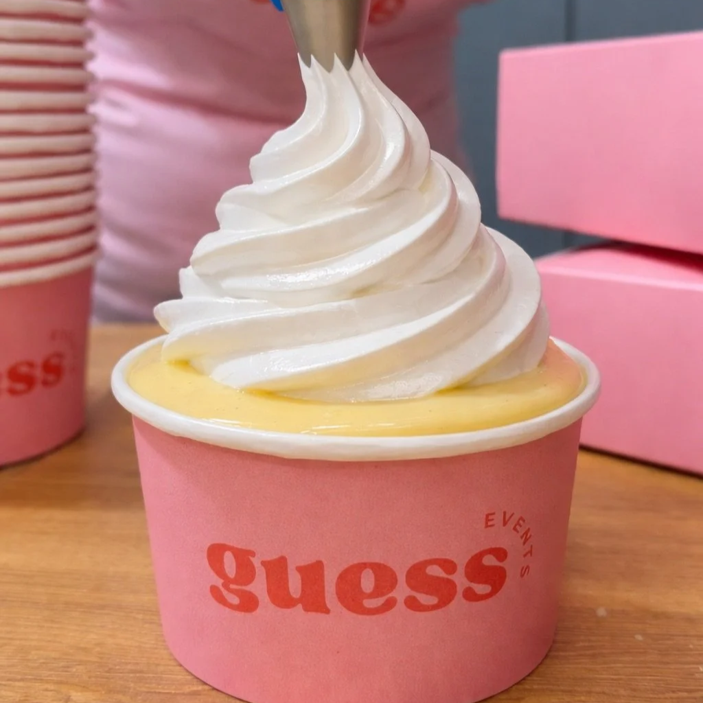 Apple crumble in a Guess Events logo pink pot, topped with custard and a meringue swirl.