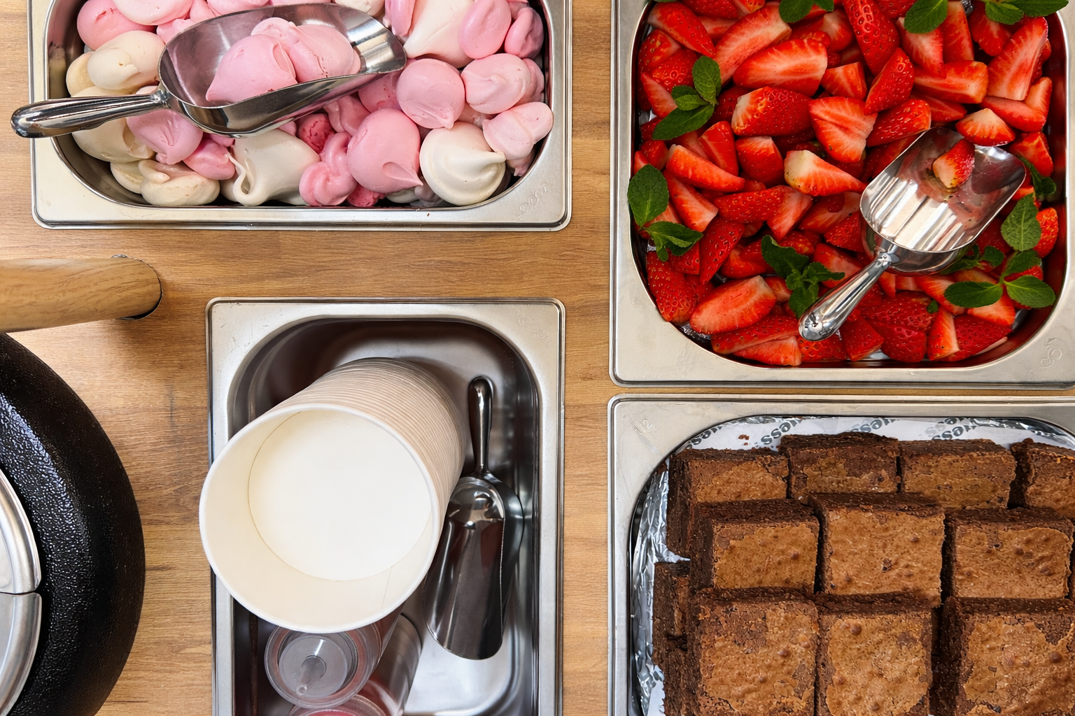 Aerial view of containers of strawberries, ice cream, meringues and brownies on the Guess Events Dessert Bar