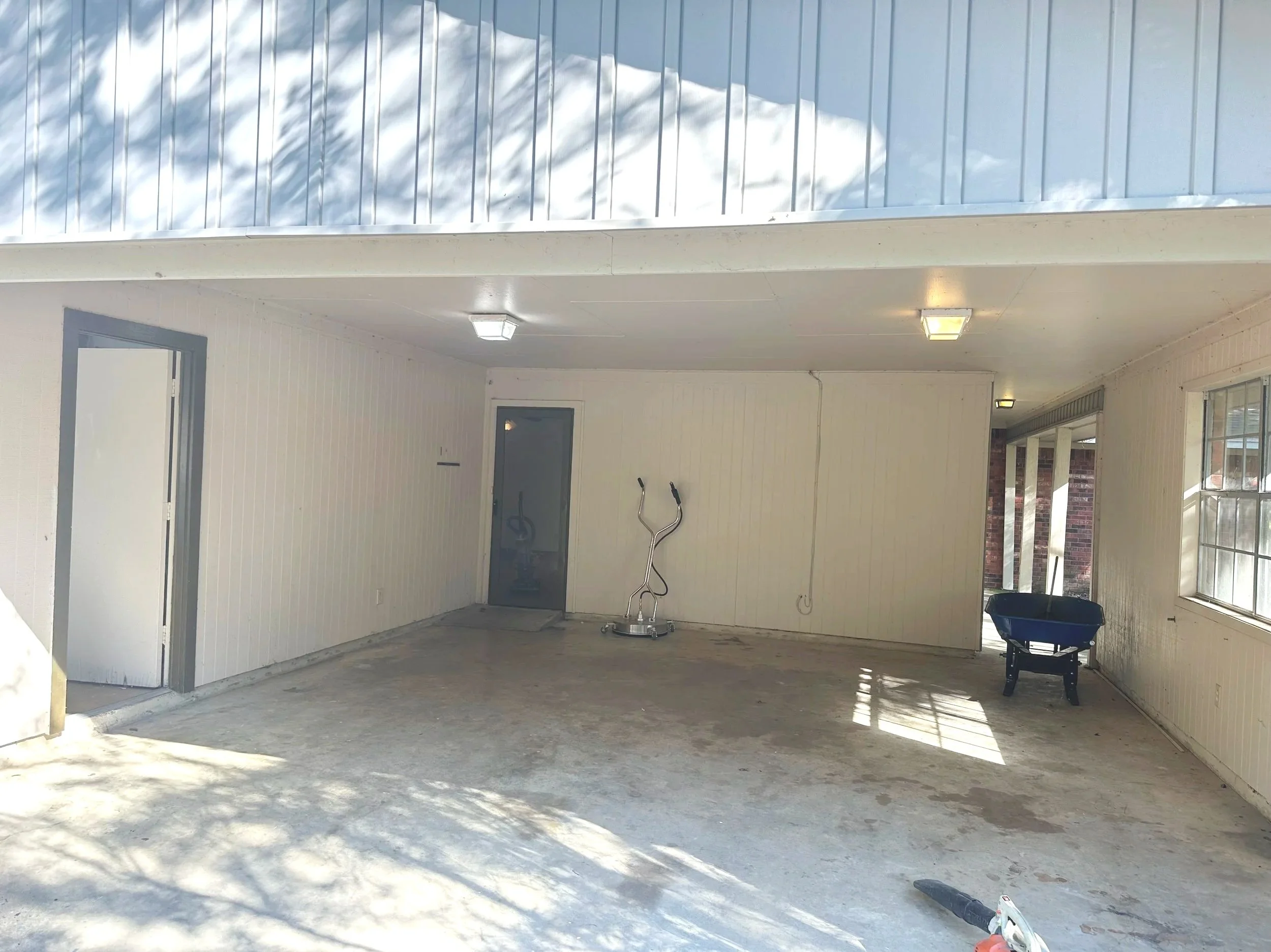 Empty garage with white walls, ceiling lights.