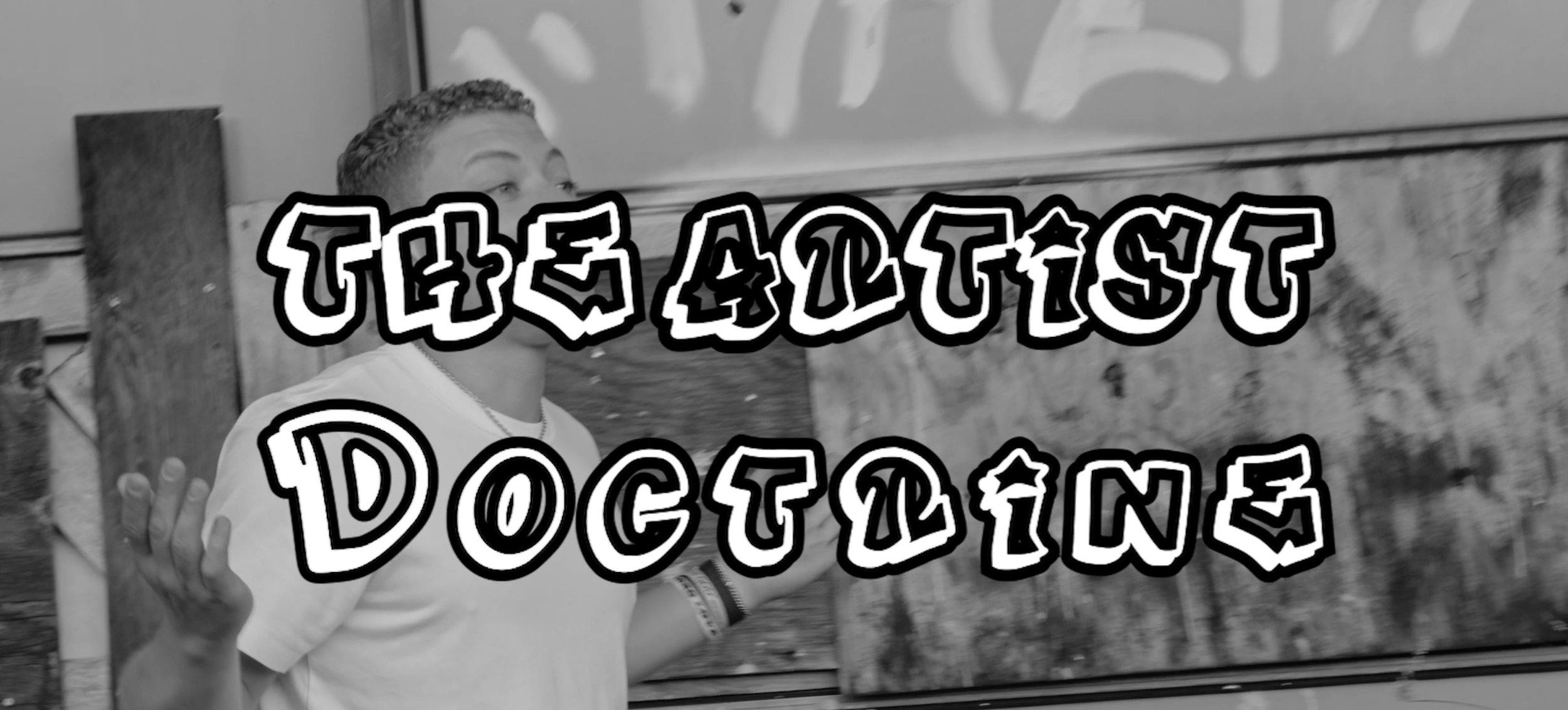 A person with short curly hair making a gesture with their hand, standing outside near a window with graffiti on the wall behind them. The image has text overlay that reads 'The Artist Doctrine' in bold, stylized font.