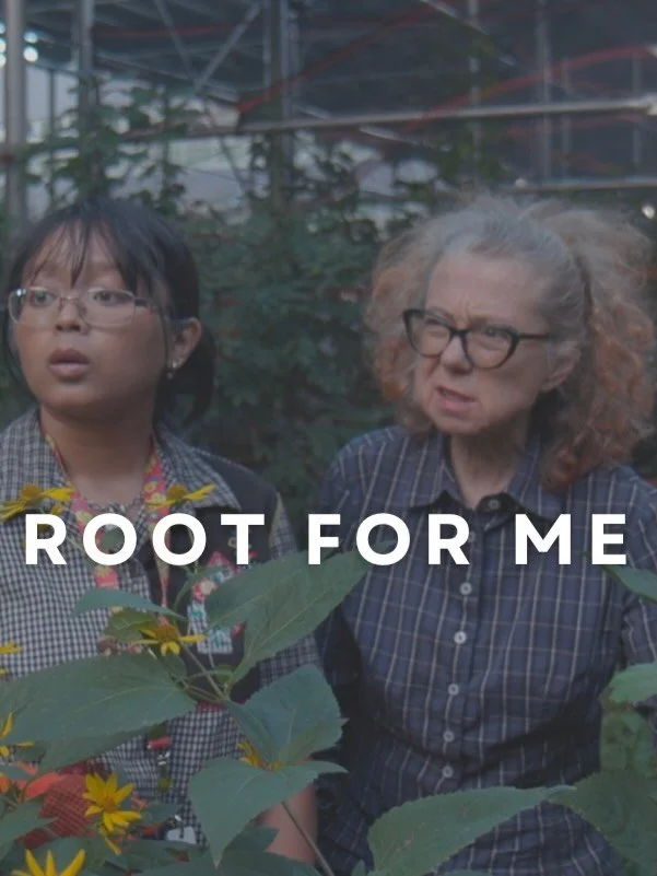 Two women, one young and one older, standing among plants at a botanical garden or greenhouse, with the text 'ROOT FOR ME' overlaid.