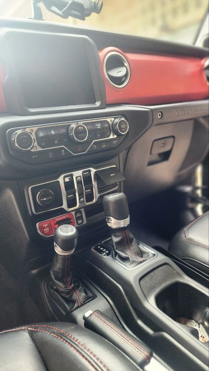 Interior of a vehicle showing the dashboard, climate controls, gear shifters, and center console.