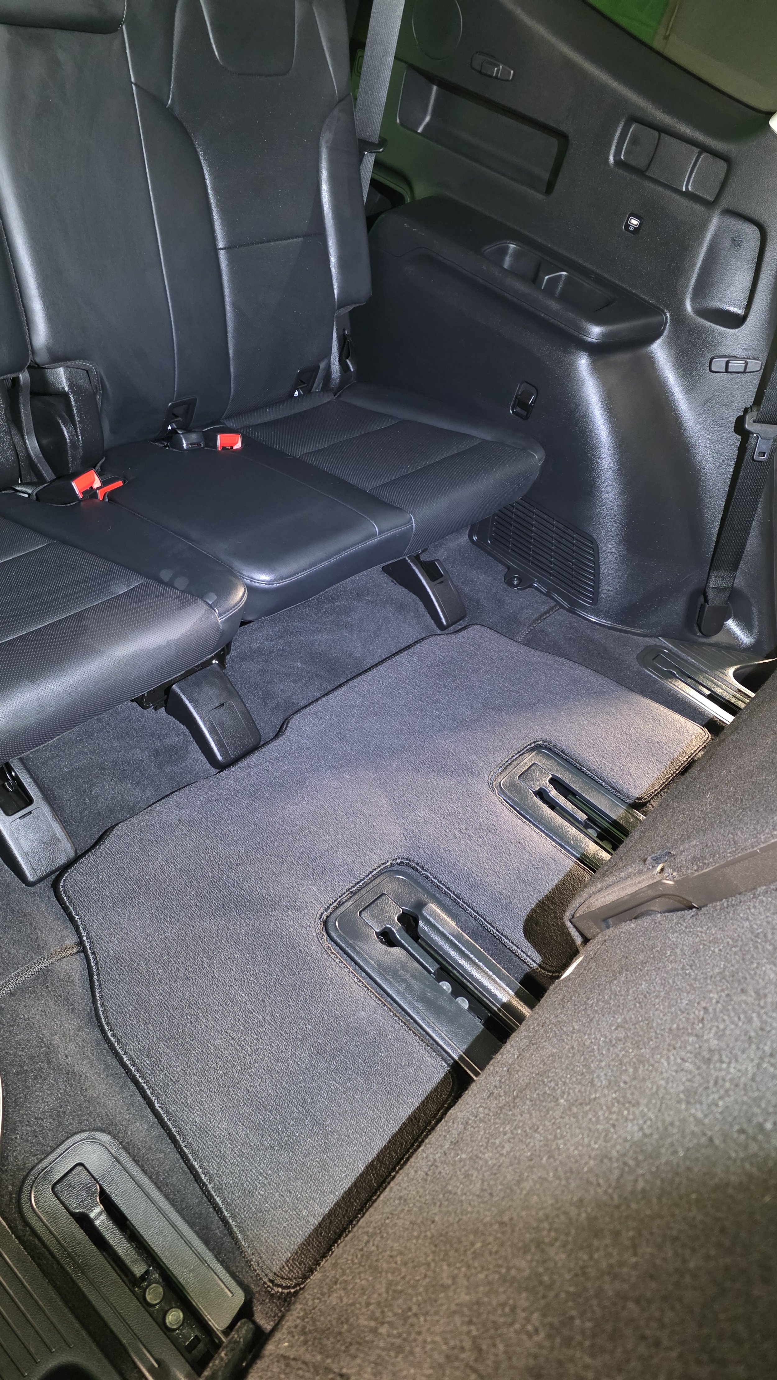 Interior of a vehicle with the back seats folded down and the floor space exposed.