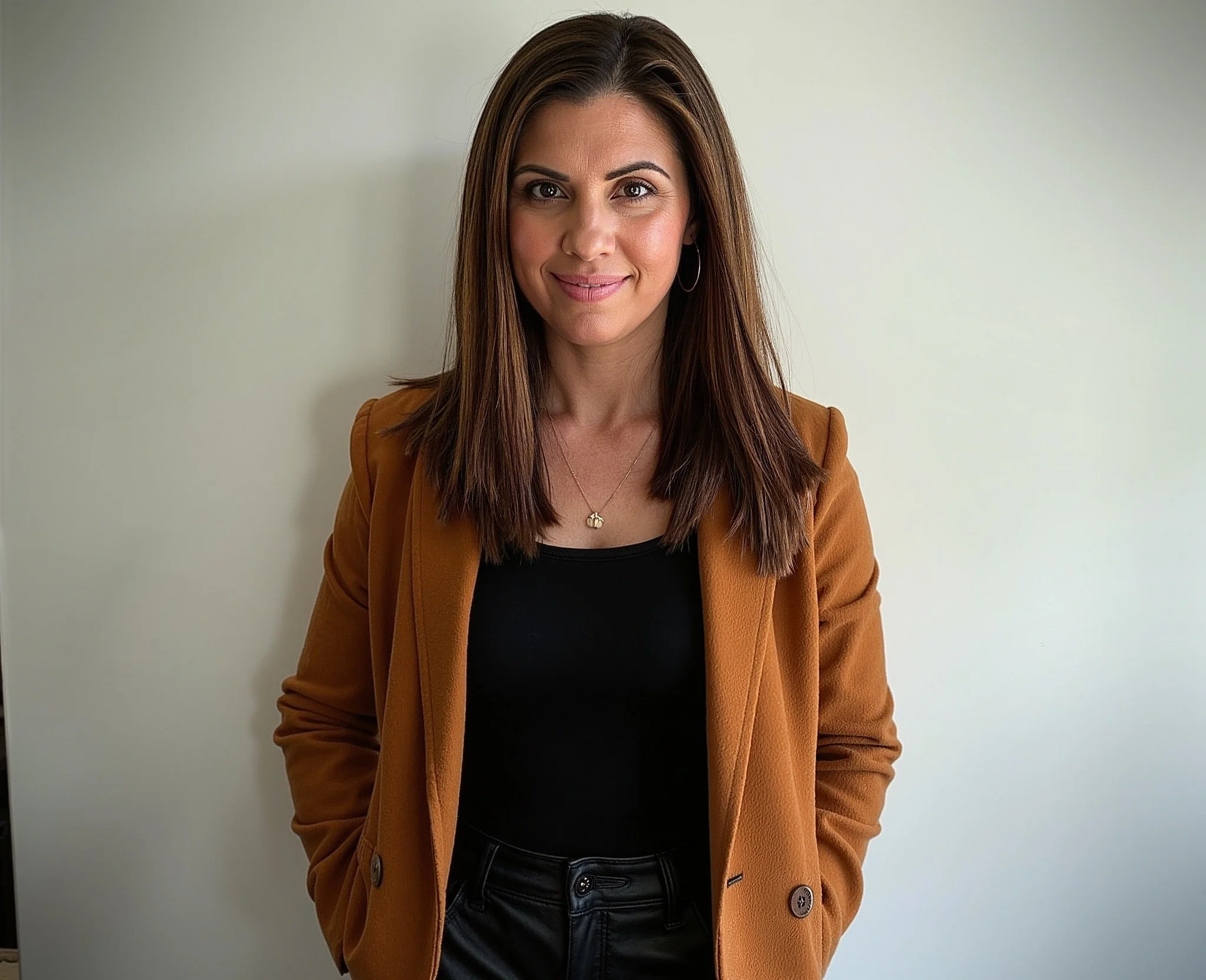 A black and white portrait of a woman with long dark hair, looking at the camera with a slight smile.