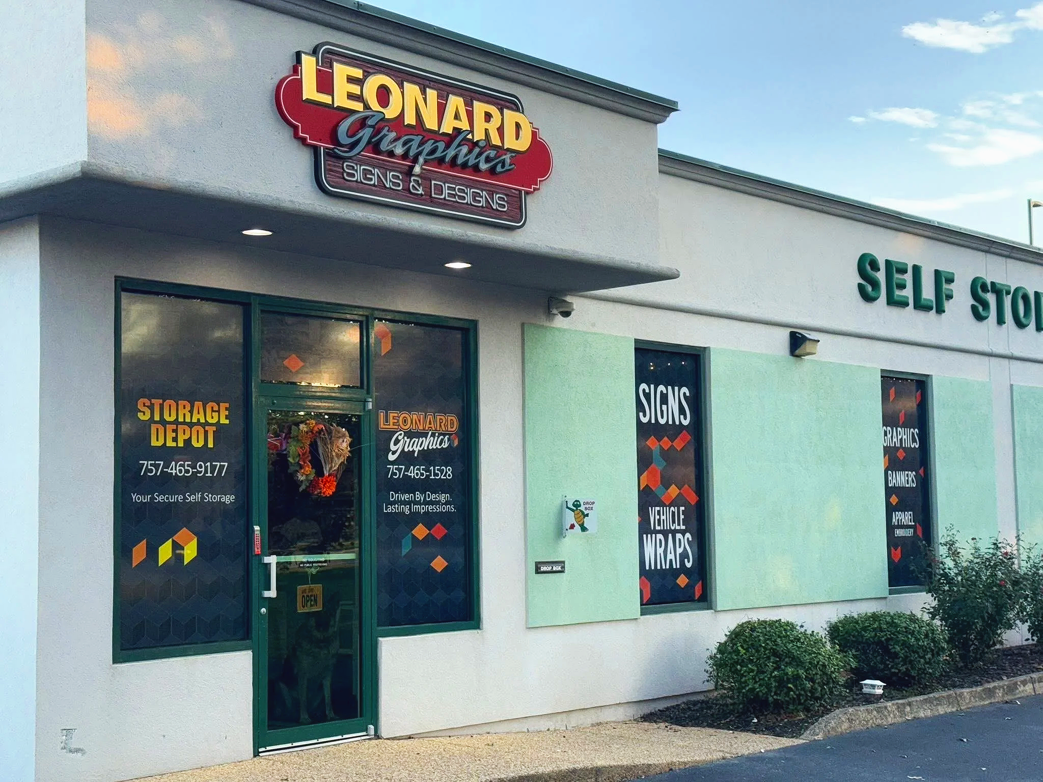 Exterior view of Leonard Graphics storefront, showing signs for signs and banners, vehicle wraps, and self storage.