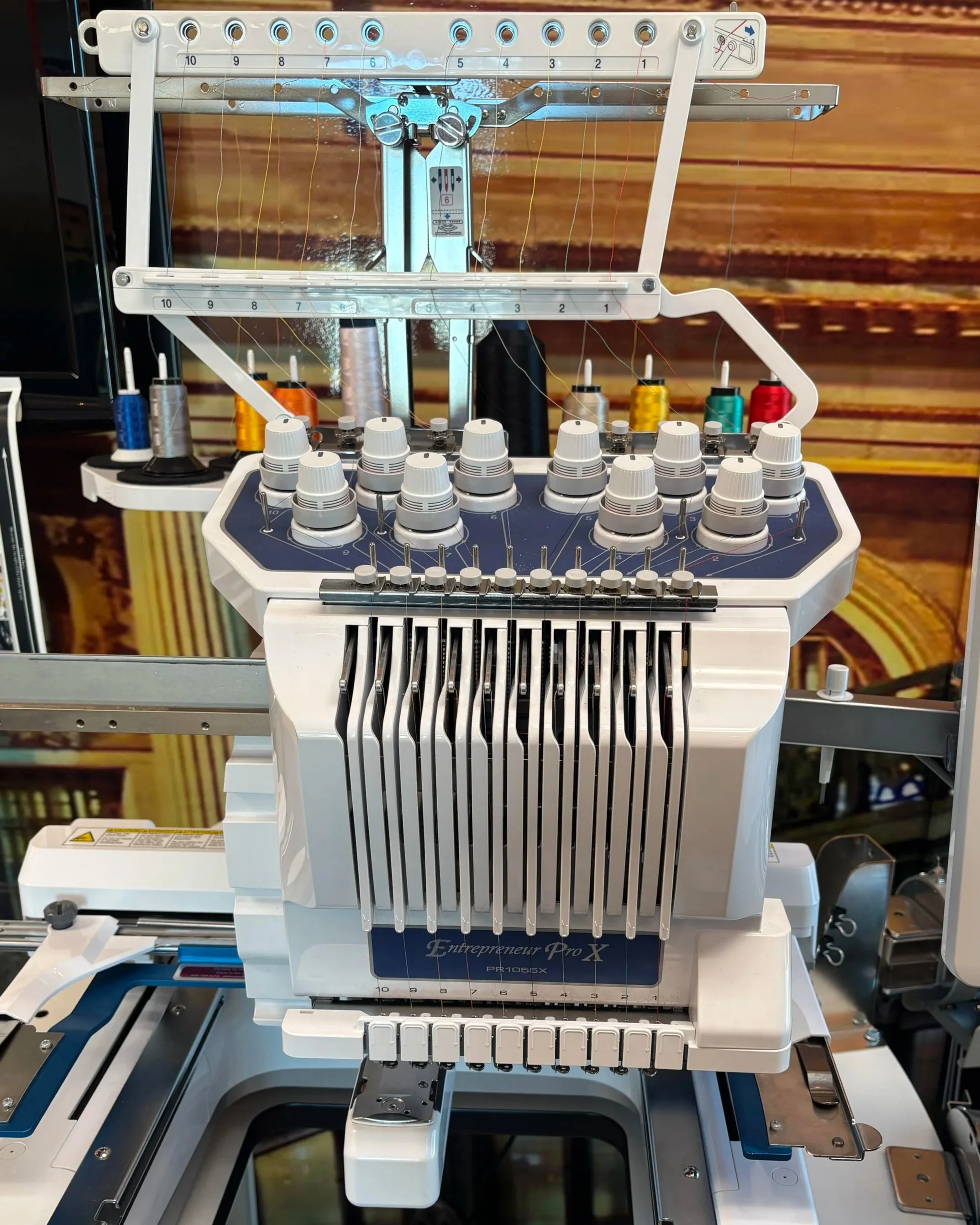Medical embroidery machine with colorful thread spools in the background.