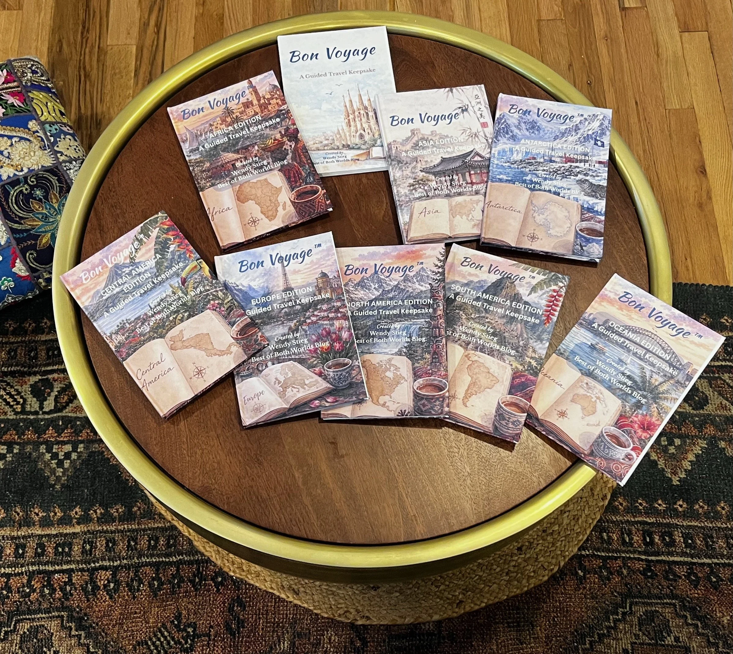 Collection of travel keepsake booklets titled 'Bon Voyage' on a round wooden table with a yellow border, placed on a patterned rug.