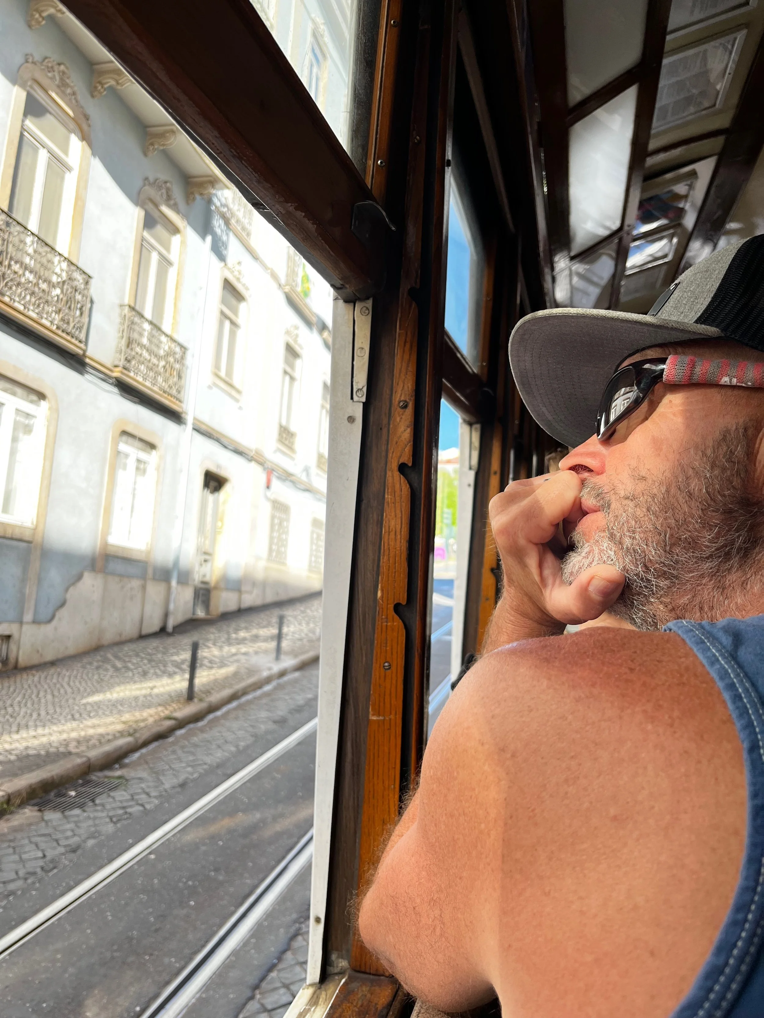 Passenger looking out the window while riding Tram 28 in Lisbon, Portugal.