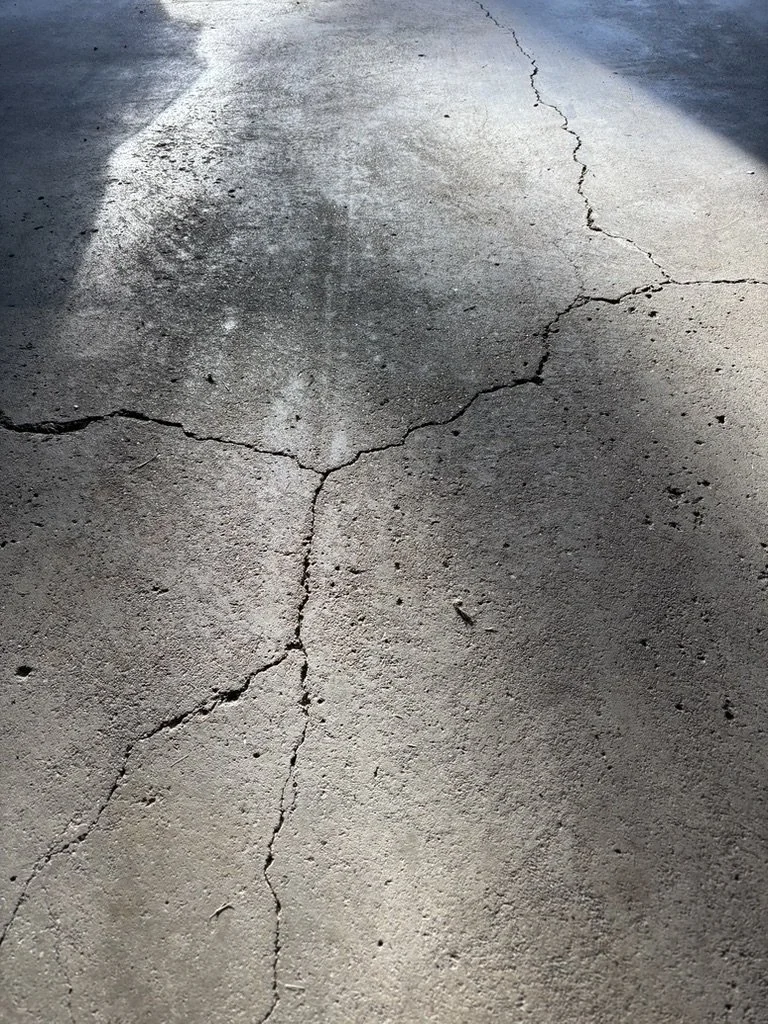 Concrete ground with cracks and shadows.