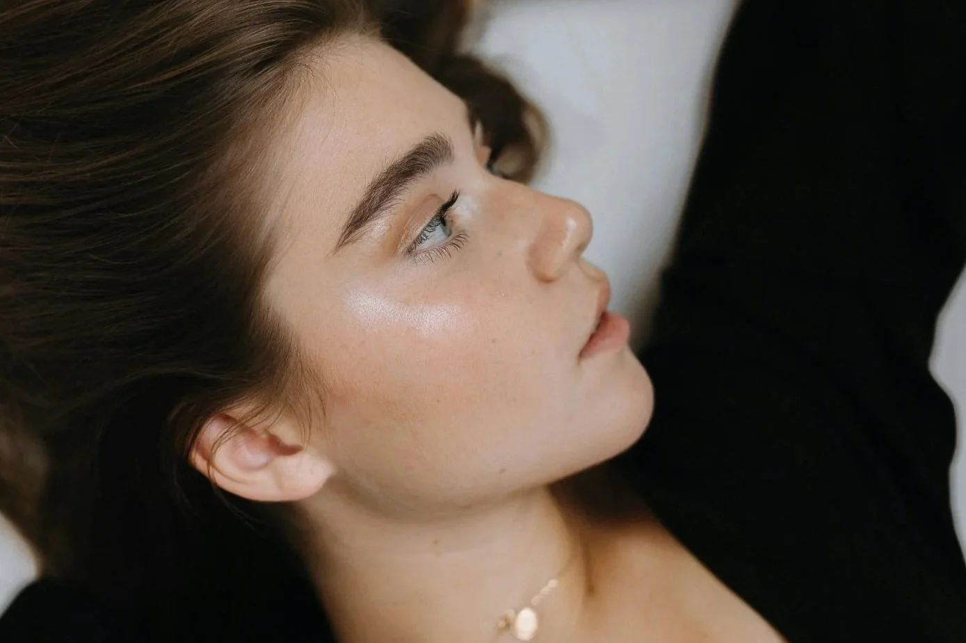 Side profile of a person with even skin tone and natural luminosity.