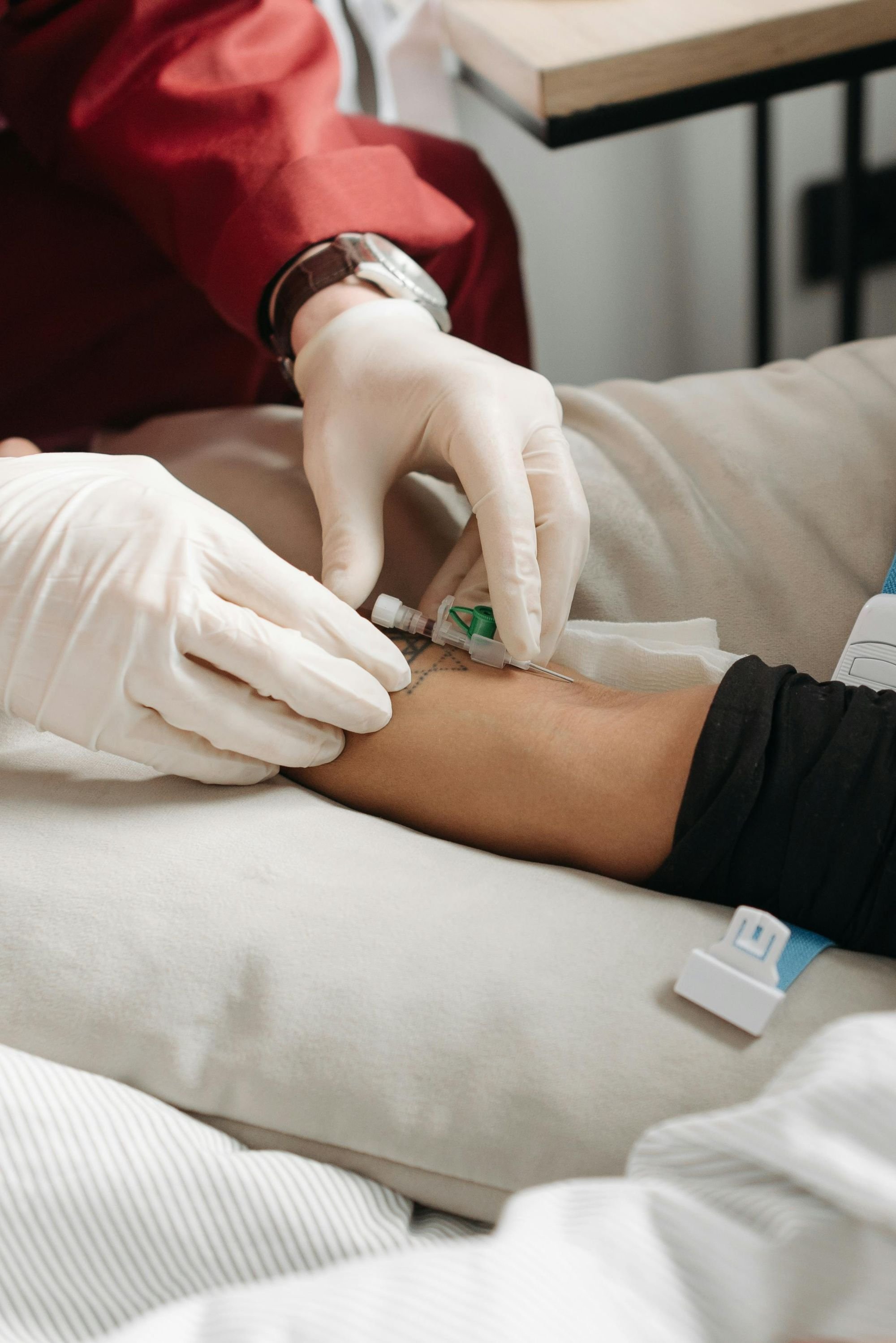 Close-up of an IV catheter being placed in the inside of a person’s elbow.