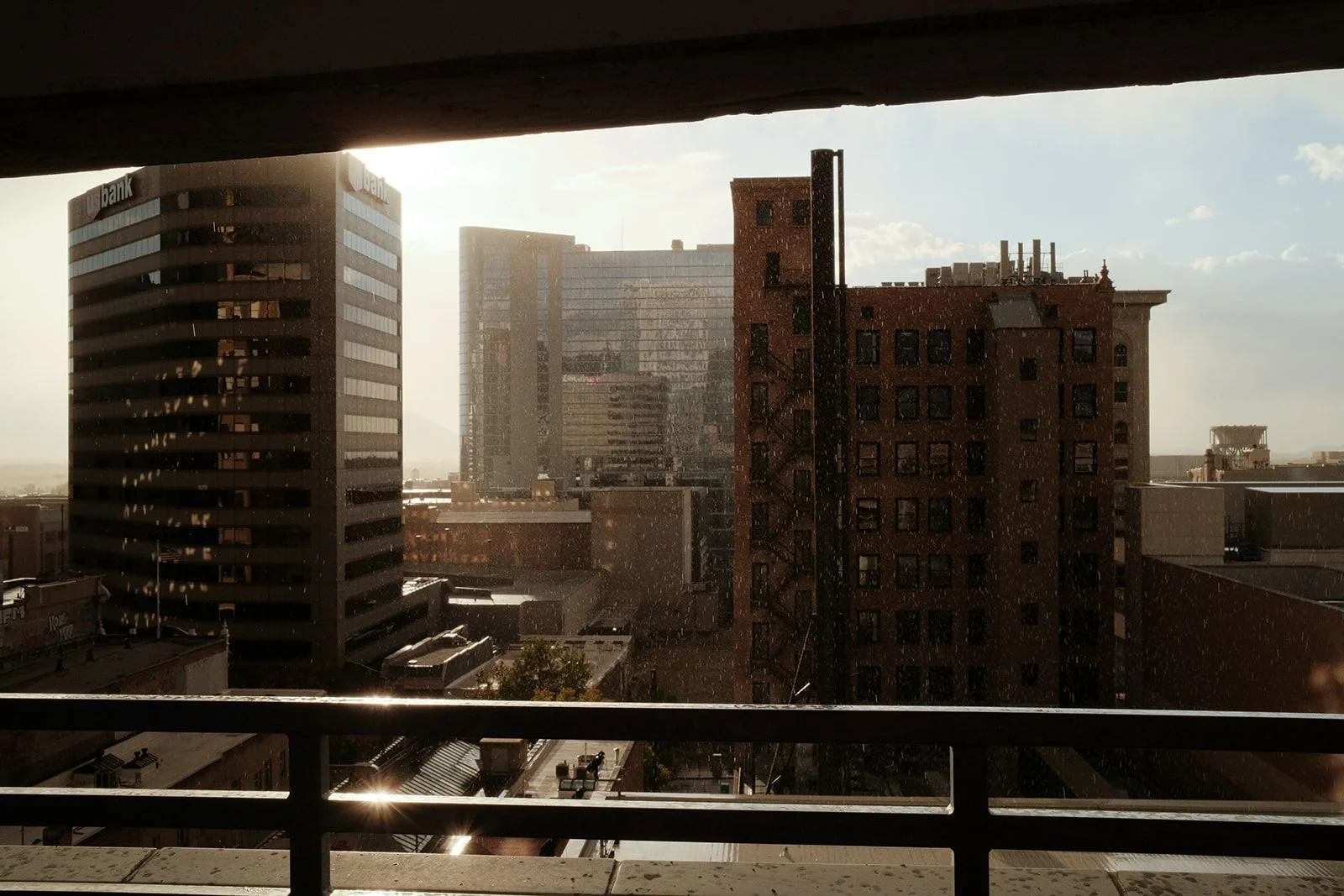 The Salt Lake City skyline and US Bank building, viewed from a balcony at golden hour.