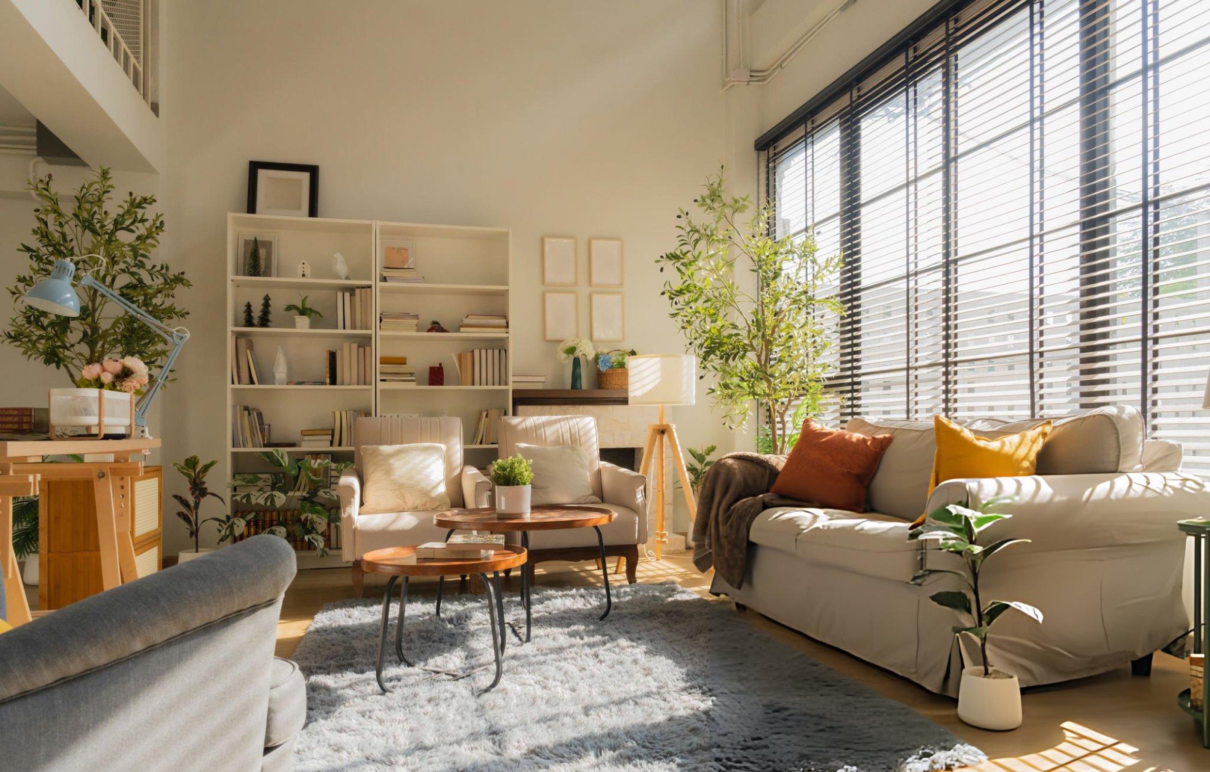 Bright and cozy modern living room with large windows, natural light, indoor plants, and warm neutral decor in a Holladay, Utah home.