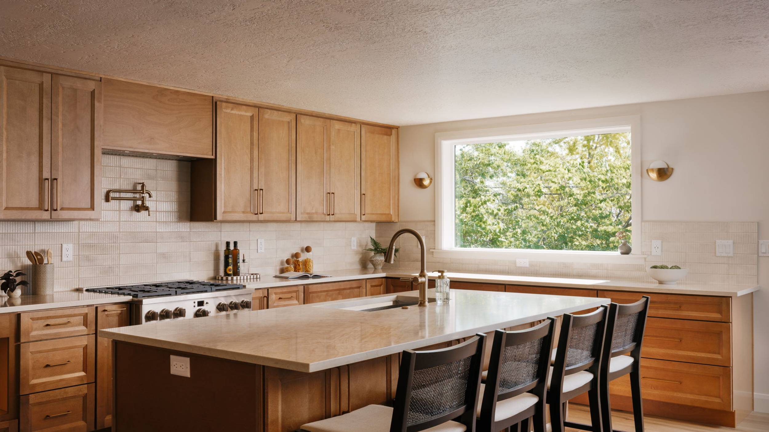 Warm, modern kitchen with wood cabinetry and a large island, highlighting the kind of home features buyers may consider when planning a Utah move.
