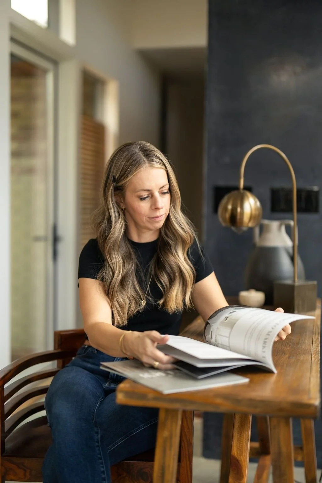 Realtor Britt Kershner sitting at a wooden table, flipping through a real estate brochure.