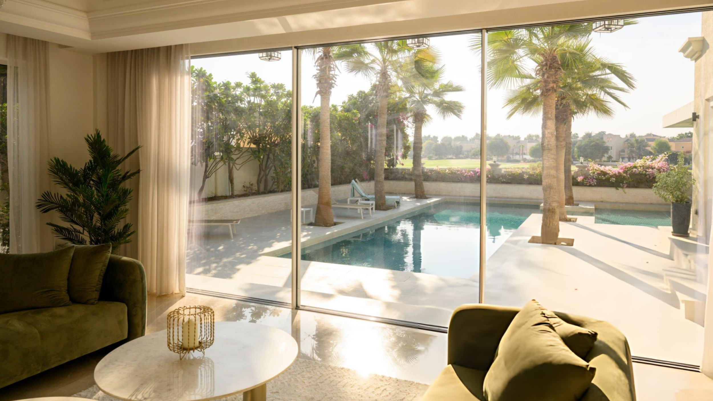 Bright luxury living space overlooking a private pool and landscaped backyard, highlighting the type of outdoor features Utah homeowners should prepare before listing during the busy summer selling season.