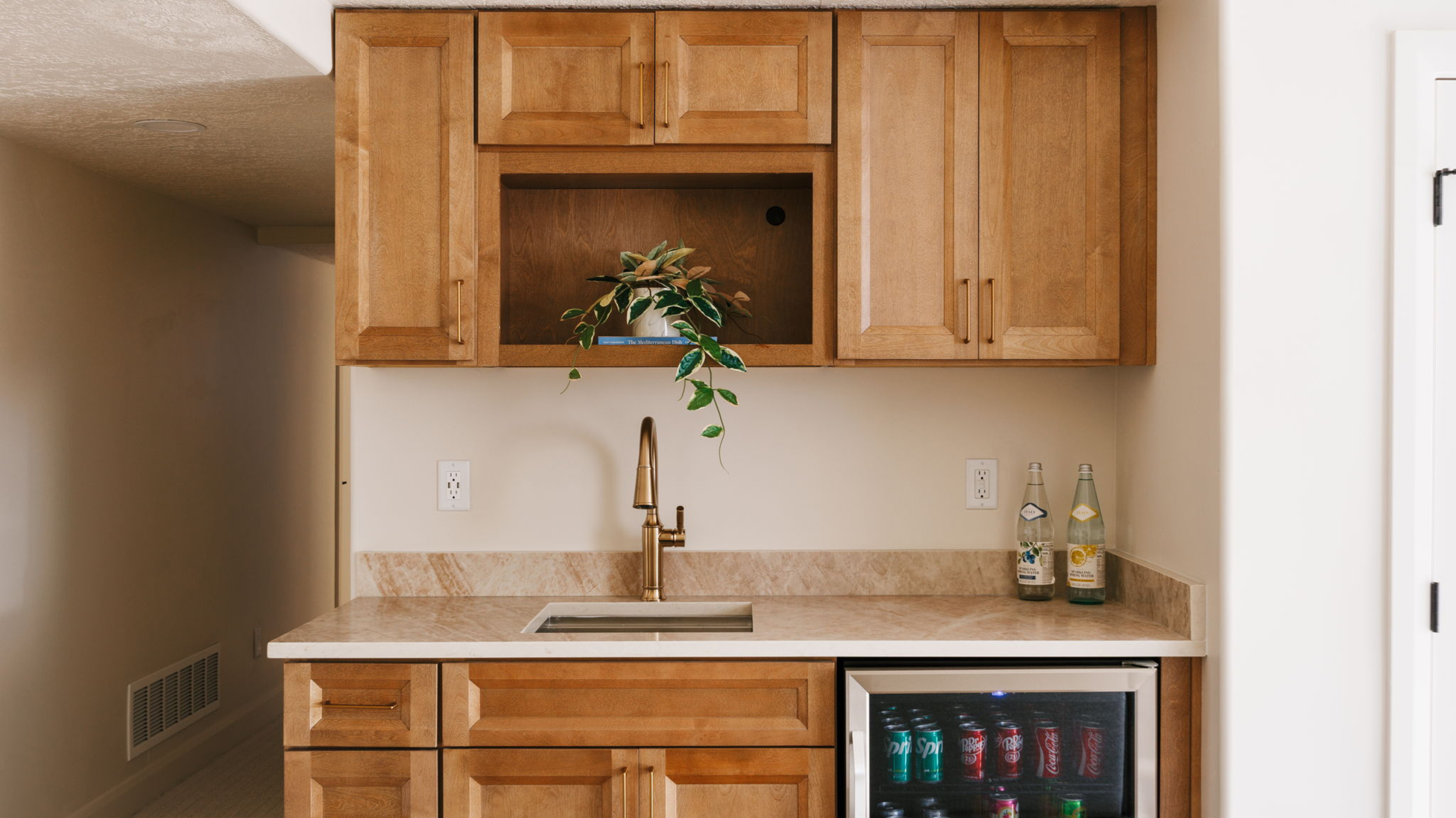 Custom home wet bar with built-in cabinetry and beverage refrigerator, showcasing the lifestyle features that add value when choosing the right Utah neighborhood beyond school ratings.