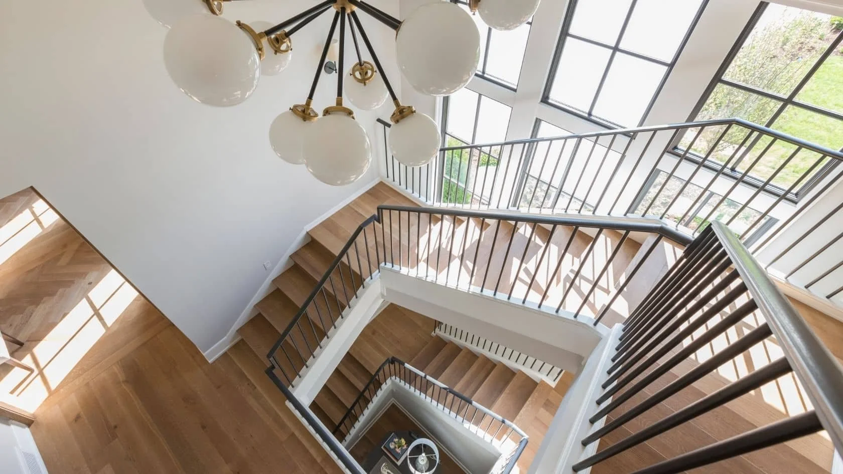 The stairwell, viewed from the third floor, of a spacious modern home located in Holladay, Utah.