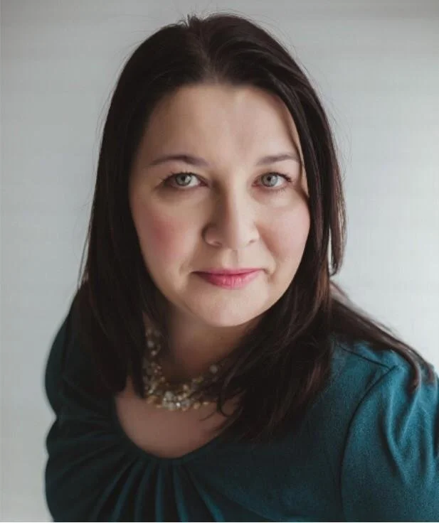 A professional of a headshot of a woman with shoulder-length brown hair