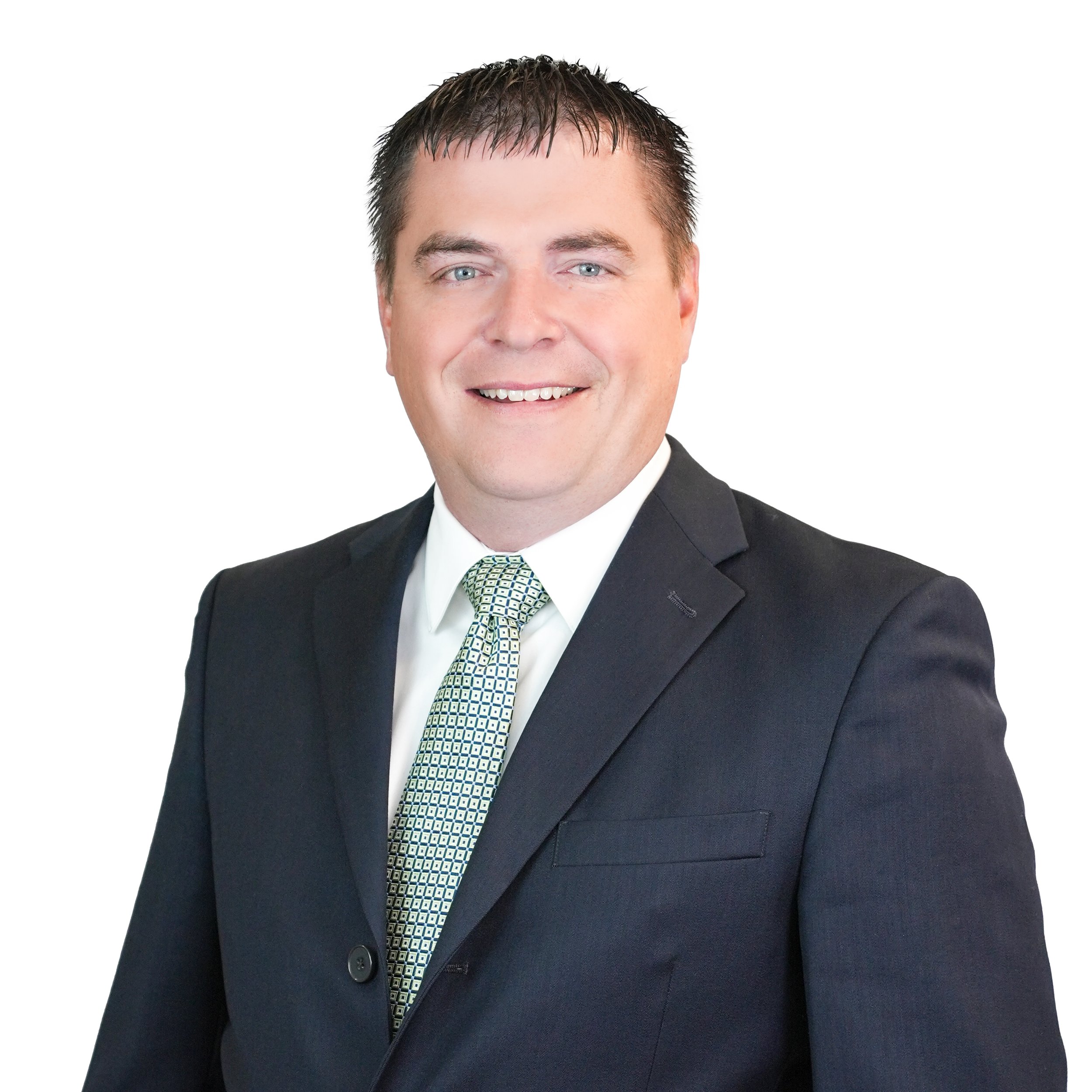Professional headshot of a smiling man in a dark suit, white shirt, and patterned tie, against a plain white background.