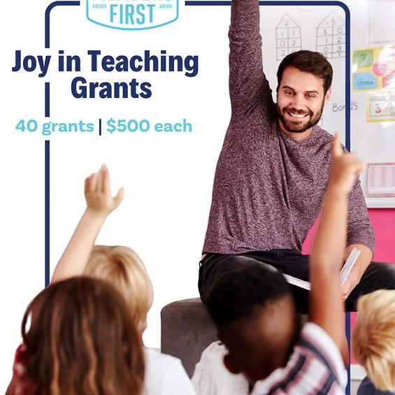 Teacher with students raising hands with "Joy in Teaching Grants" written across