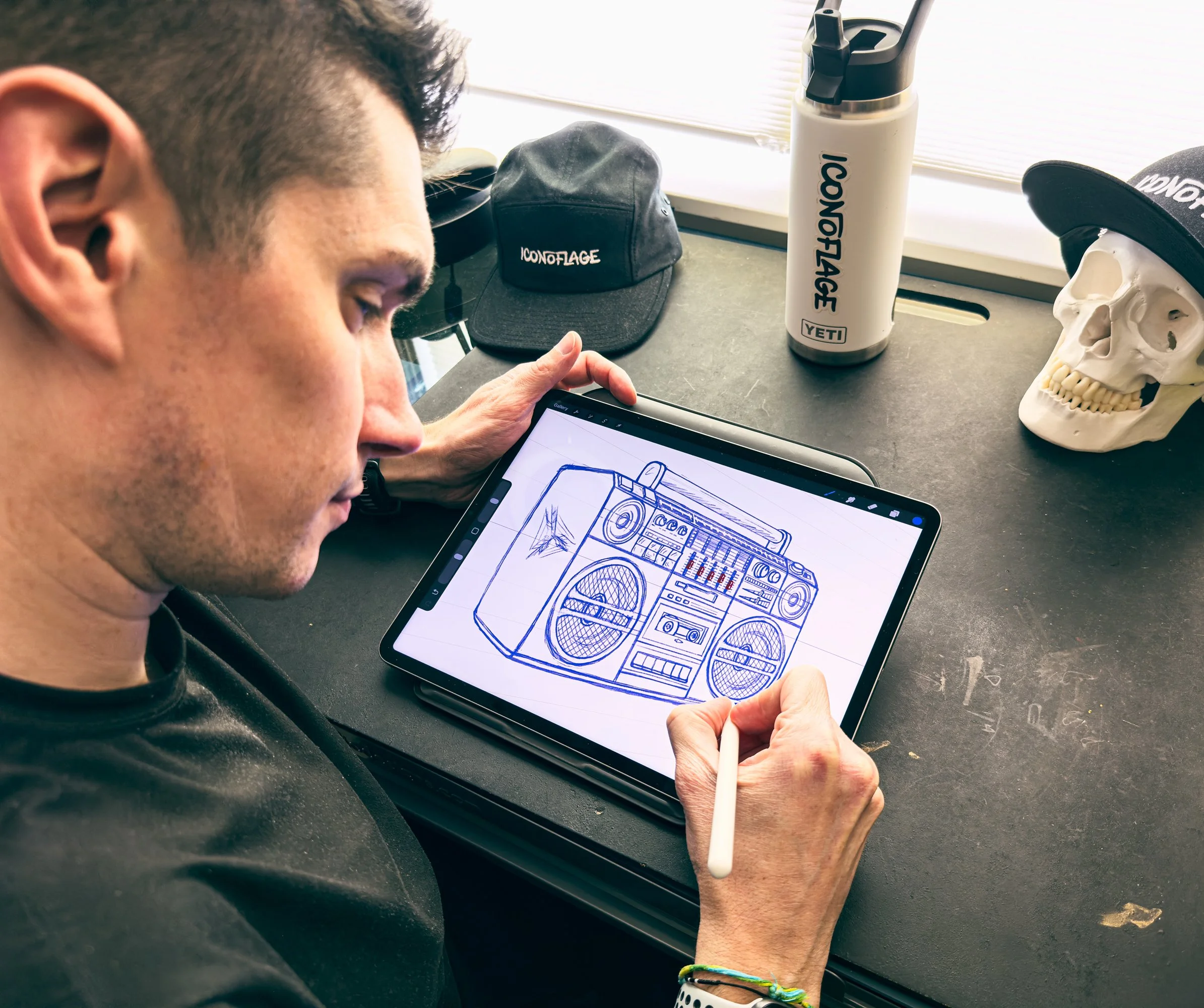Scott Hofford drawing New Image Brewing boom box illustration on iPad Pro with Apple Pencil in studio workspace