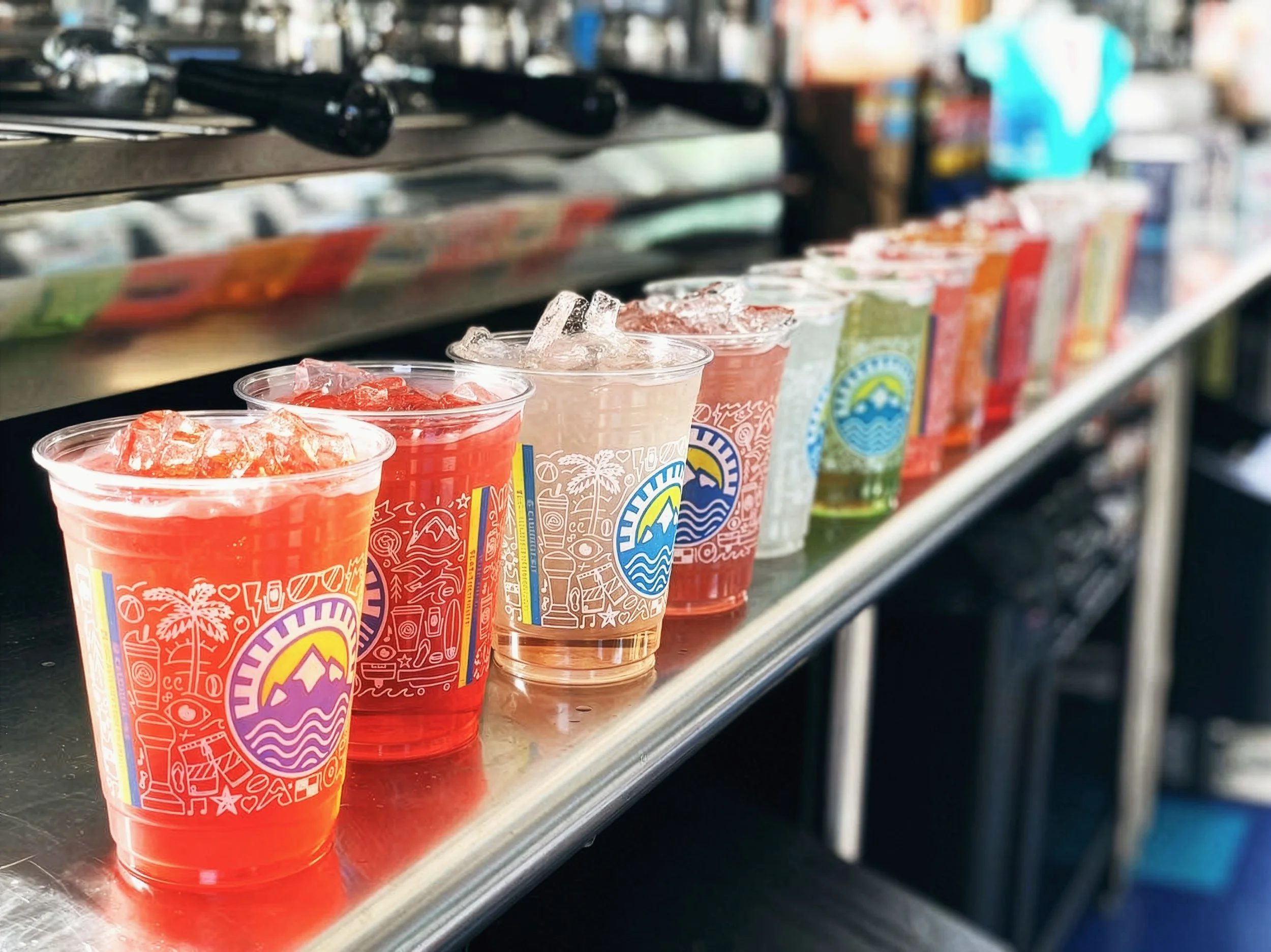 Cali Coffee cold cups with Iconoflage pattern in multiple colorways filled with colorful beverages