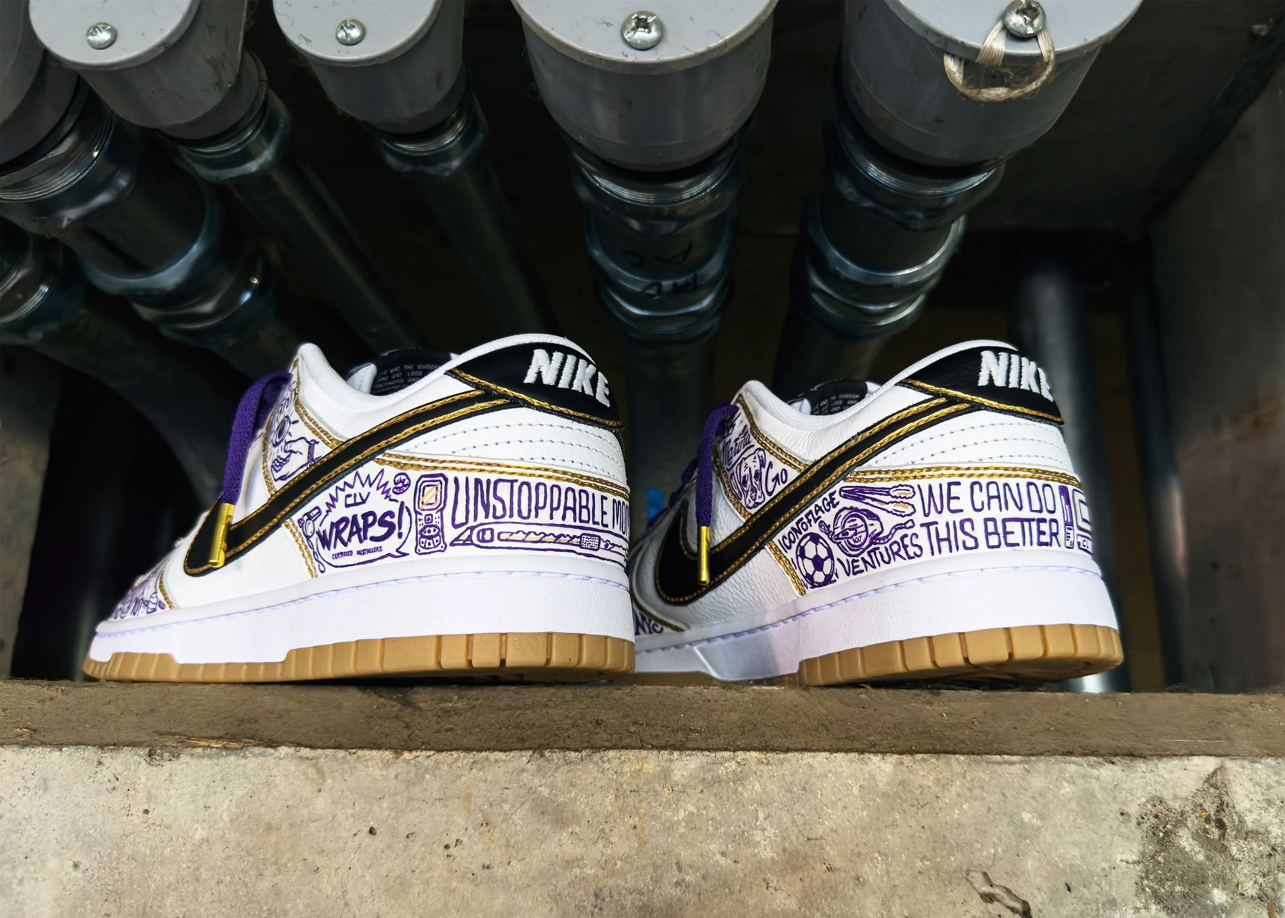 Rear view of custom Nike Dunks pair showing "CLV WRAPS!" and "WE CAN DO THIS BETTER" text detail