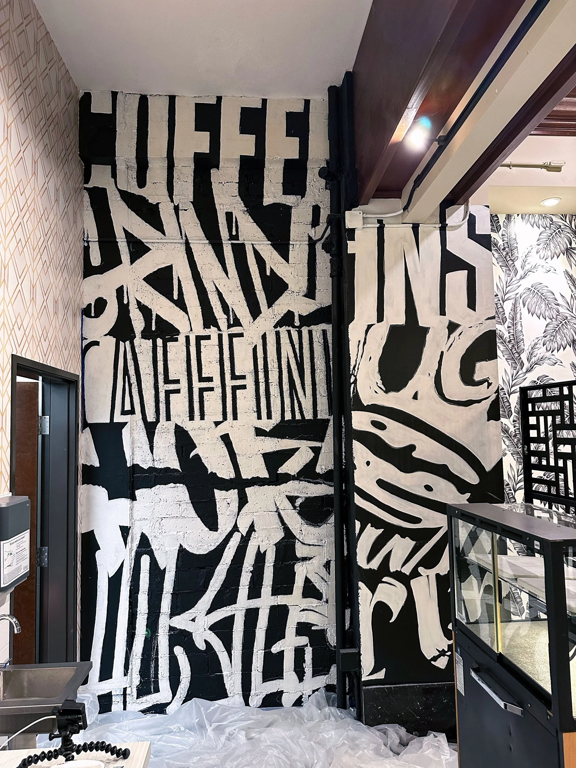 Sparrow Nest Coffee typographic mural installed in cafe interior