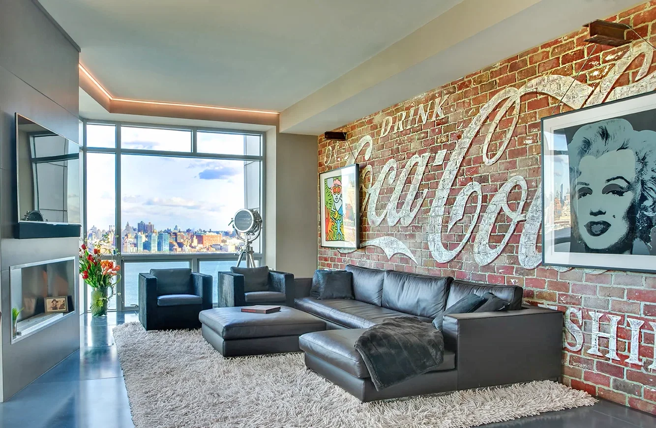 Modern living room with large window view at The W Hotel Residences in Hoboken, with vintage Coca-Cola sign on brick wall, and a shag rug.