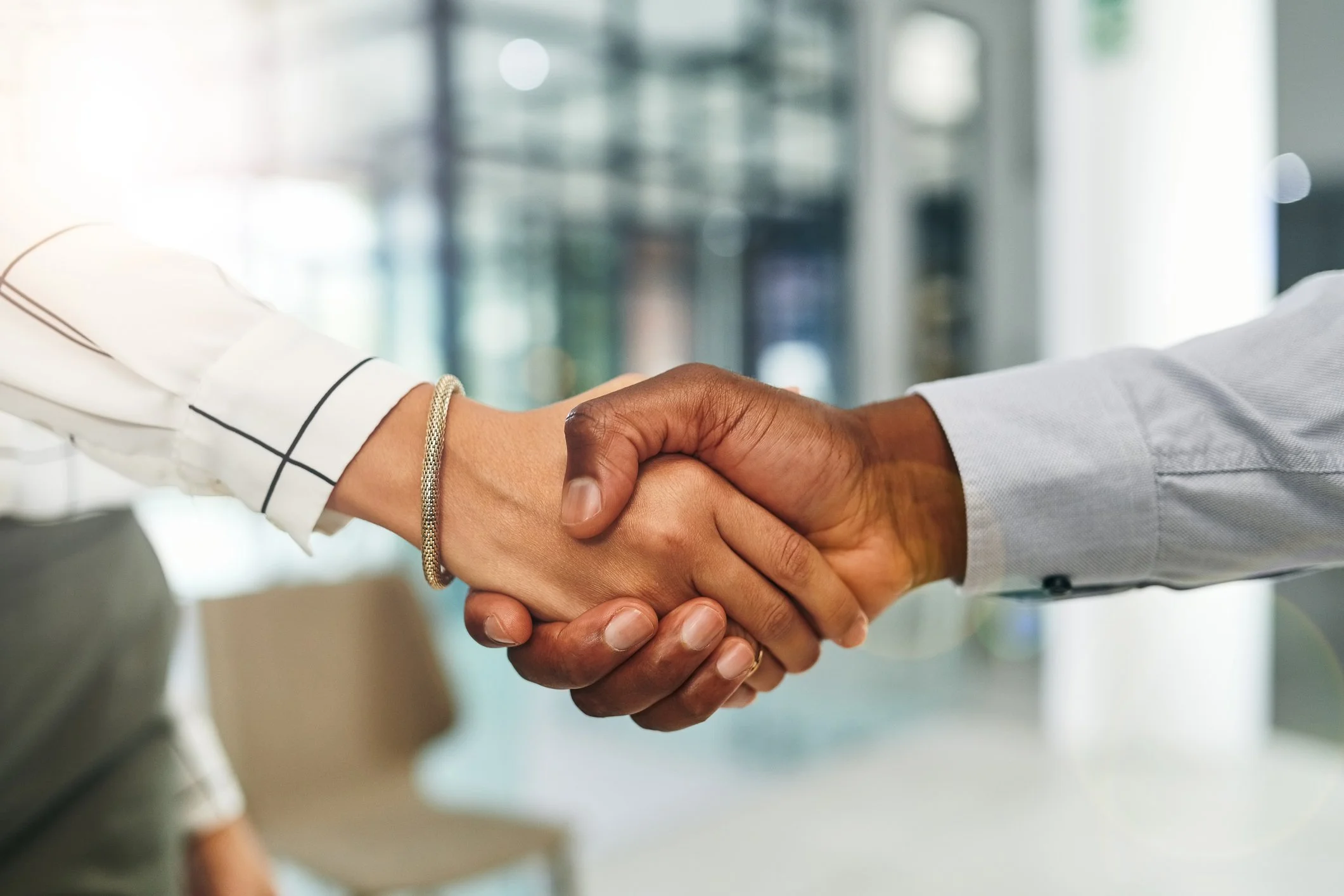Two people shaking hands to symbolize trusted daily money management support