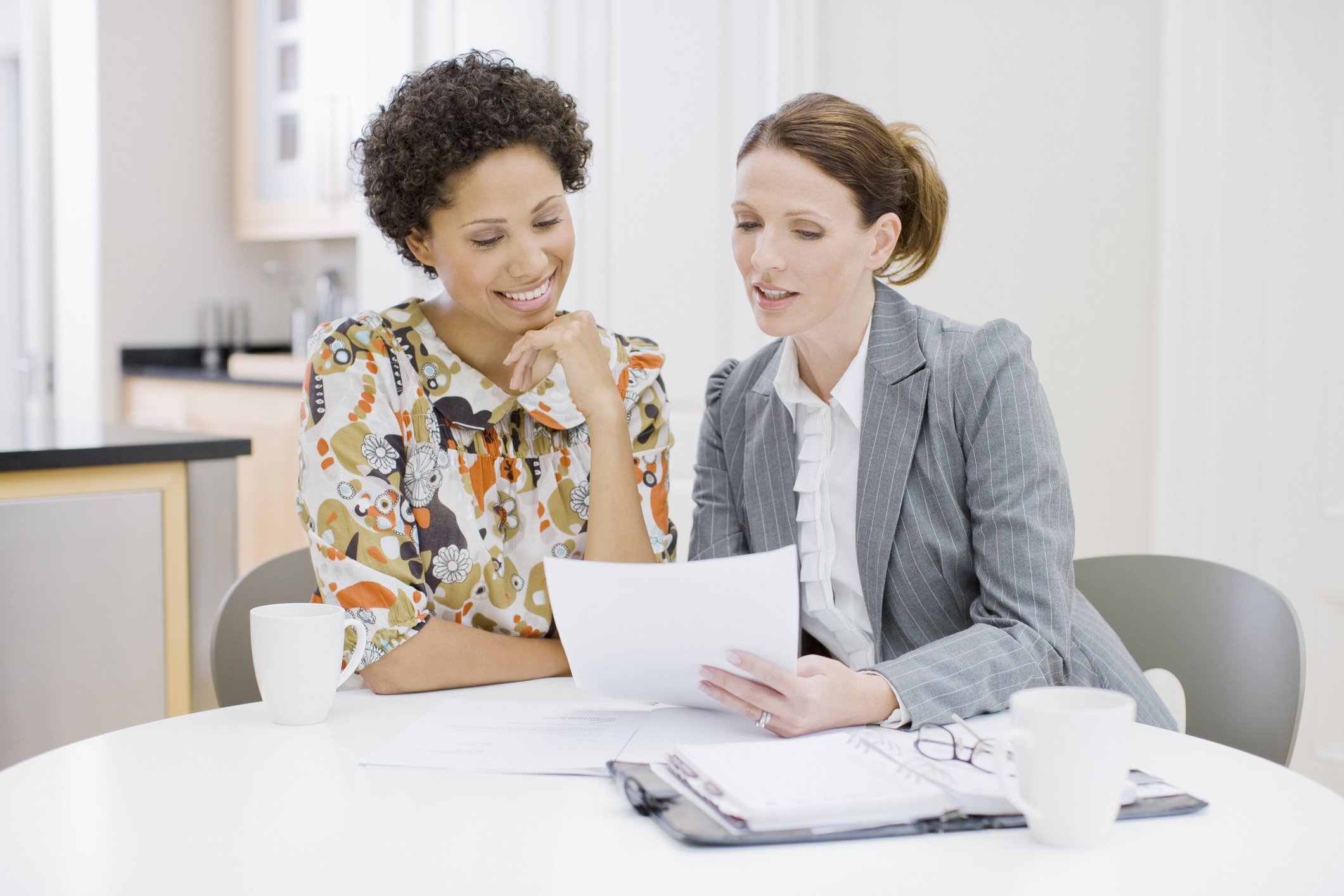 A daily money manager reviewing financial paperwork with a young professional woman