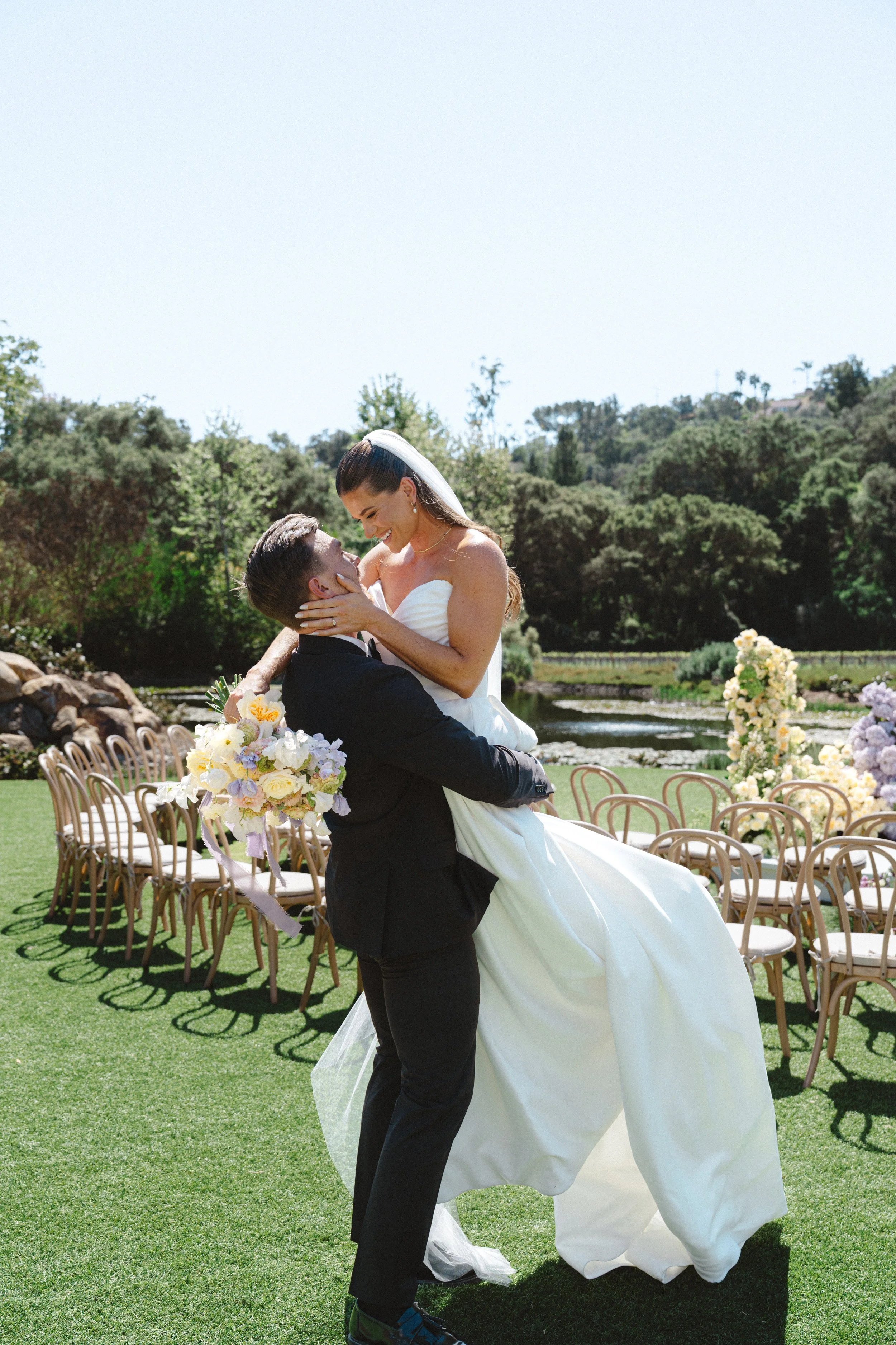 Joyful bride and groom moment during ceremony at Monserate Winery in Fallbrook with soft light and romantic florals
