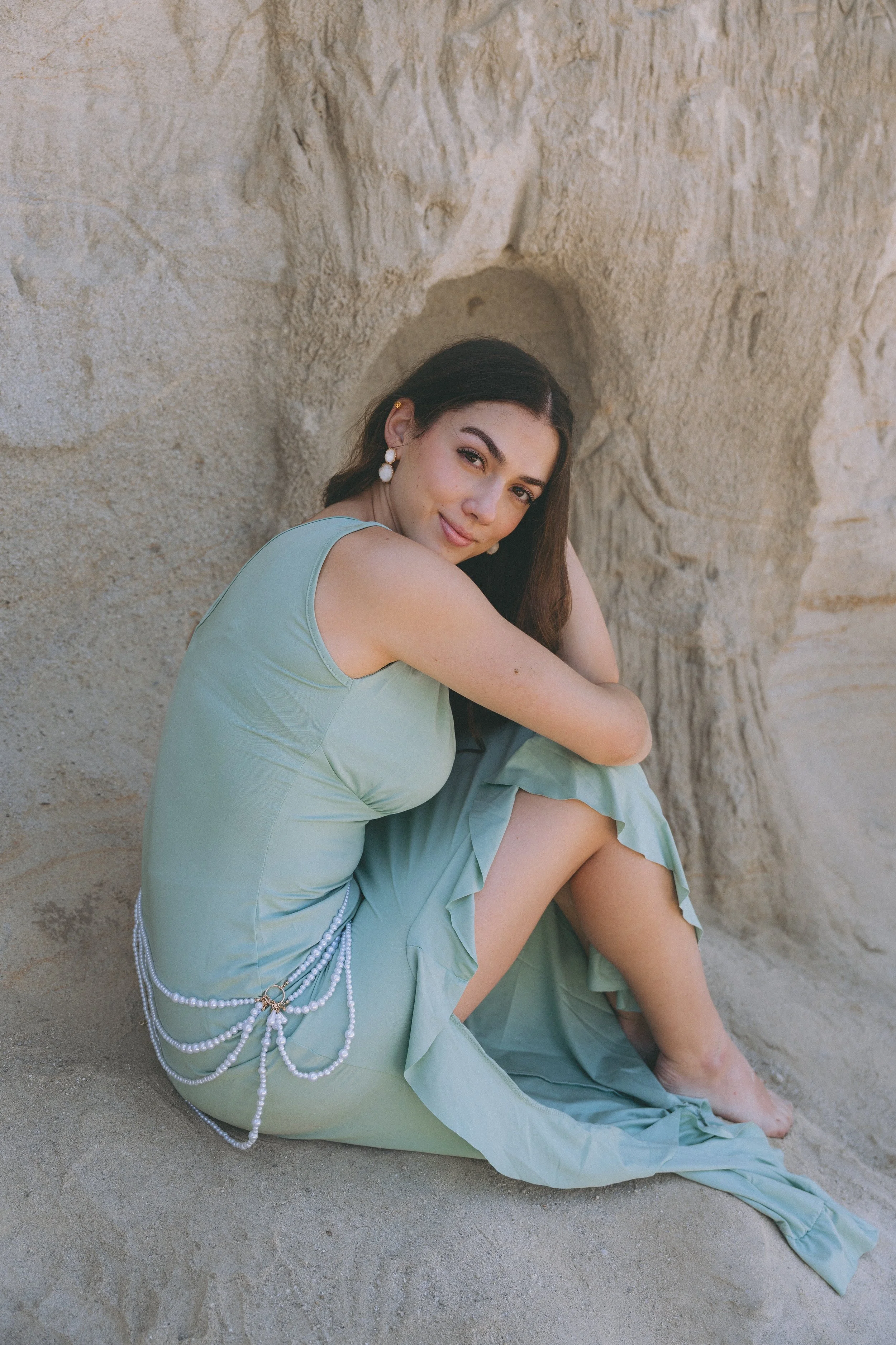 Dreamy mermaid-inspired beach portrait at San Clemente Beach with a flowing seafoam dress and coastal cliff backdrop.
