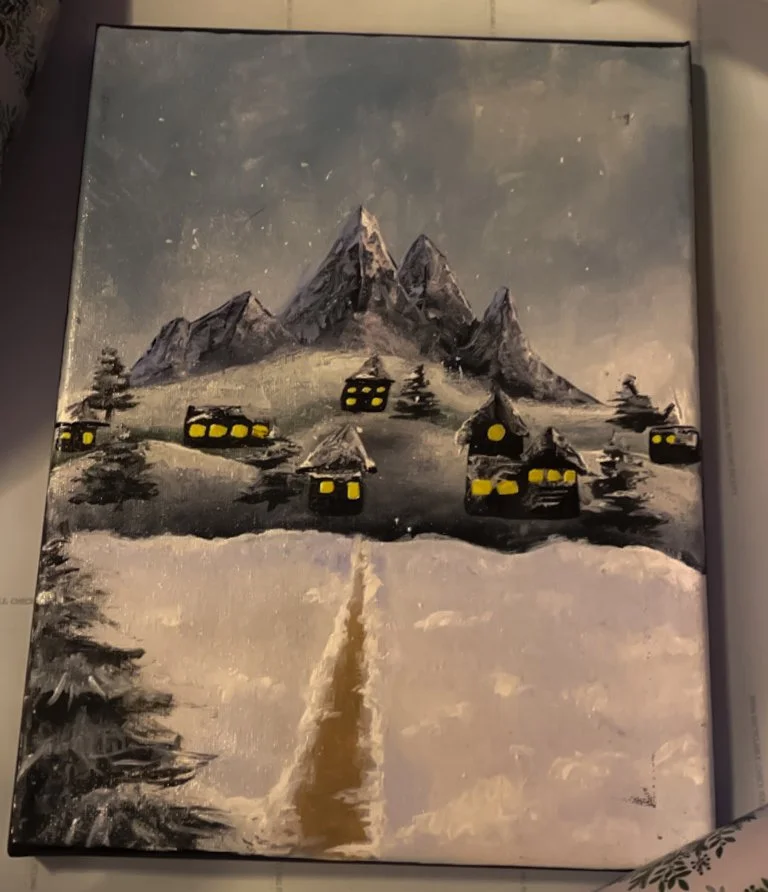 Snow-covered mountain village with dark sky and lit windows.