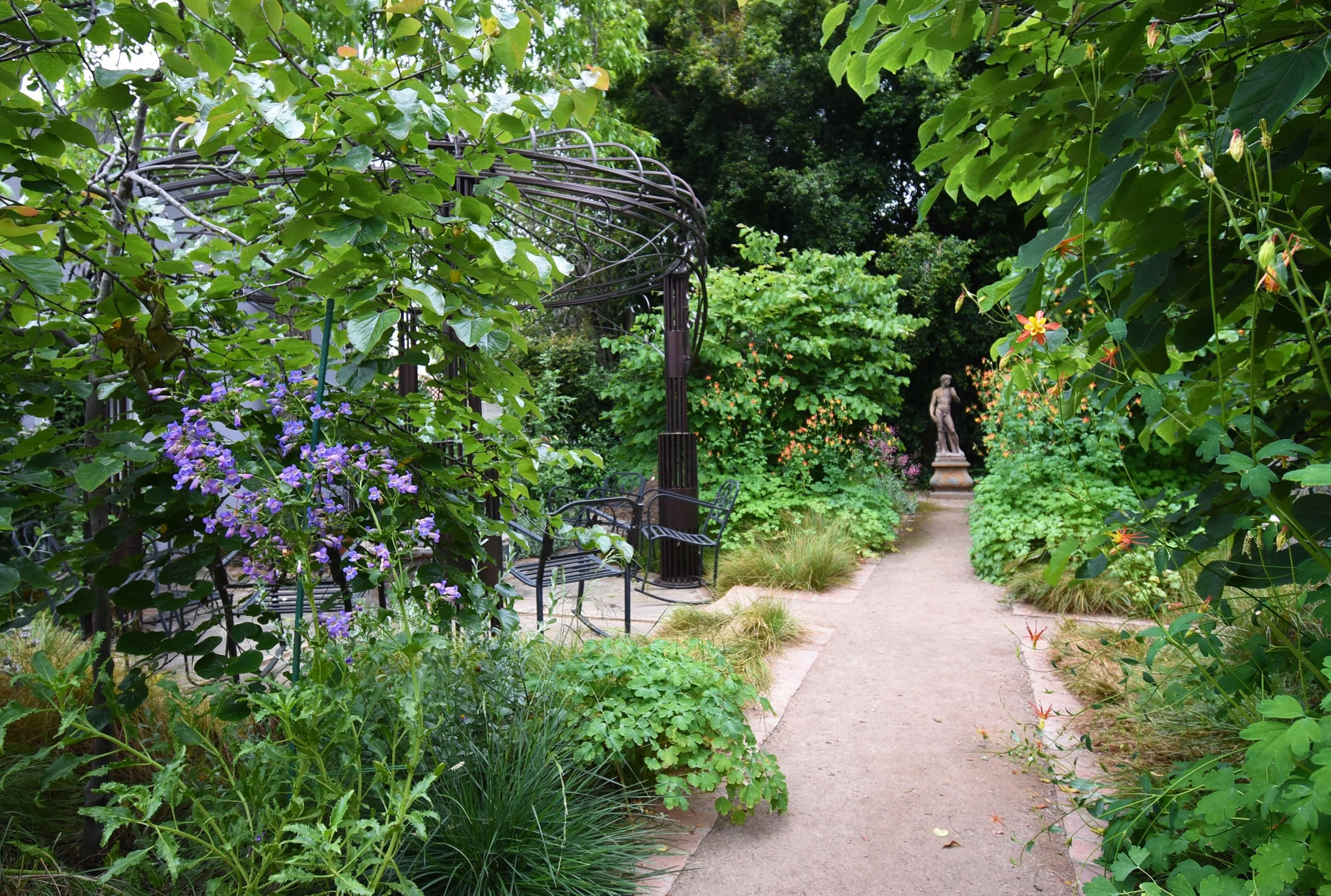 Garden with iron trellis and italian statue
