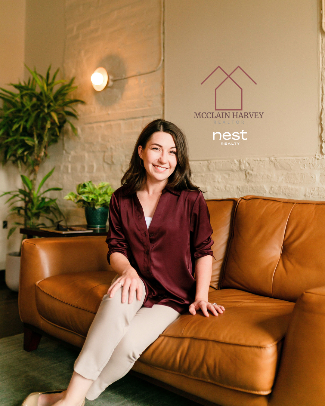 A woman sitting on a leather couch in an indoor setting with plants in the background. There are logos for McClain Harvey Realtor and Nest Realty in the upper right corner.