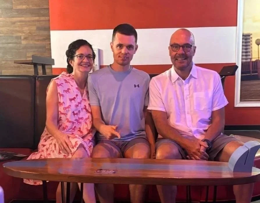 peter between mum and dad on a family seater