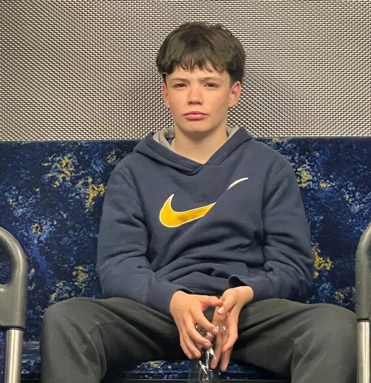 mich's son sitting on a sofa holding a water bottle