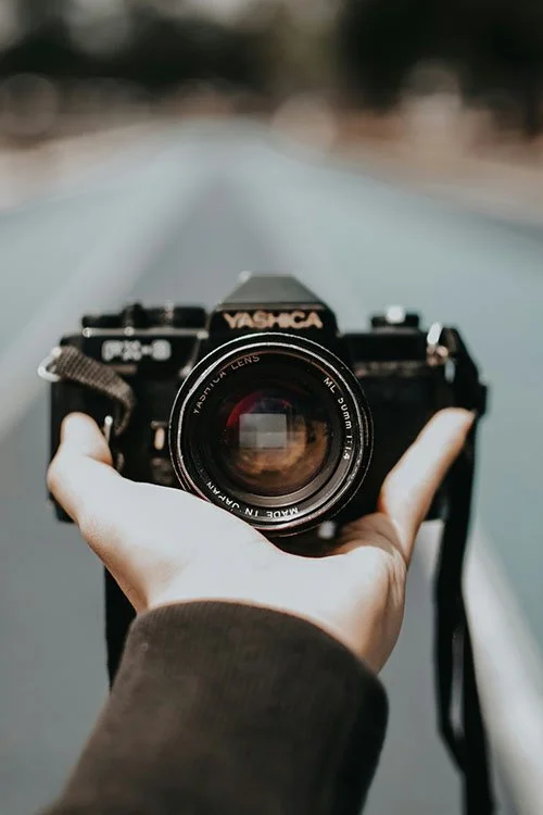 A close up of a camera in someone's hand facing them.